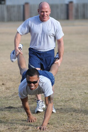 U.S. Air Force Staff Sgt. James Hubby holds Senior Airman Terrell Pretlow's legs during a human wheel barrel event during the Airman Leadership School and First Term Airmen Center fitness challenge at the base picnic grounds here Feb. 1, 2010. The two organizations hold regular fitness challenges and competitions to promote a positive, team building experience, while boosting the fun of their physical training. Sergeant Hubby is with the 628th Comptroller Squadron and Airman Pretlow is with the 628th Civil Engineer Squadron and both are currently attending ALS. (U.S. Air Force photo/James M. Bowman)