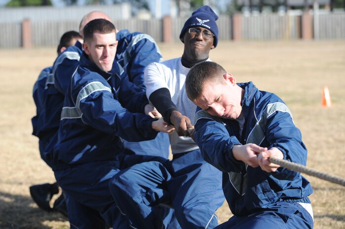 U.S. Air Force Airman Barry Farese and Airmen 1st Class Jamel McCargo and Tyler Wehrung participate in the tug-of-war portion of the Airman Leadership School and First Term Airmen Center fitness challenge at the base picnic grounds here Feb. 1, 2010. The two organizations hold regular fitness challenges and competitions to promote a positive, team building experience, while boosting the fun of their physical training. (U.S. Air Force photo/James M. Bowman)