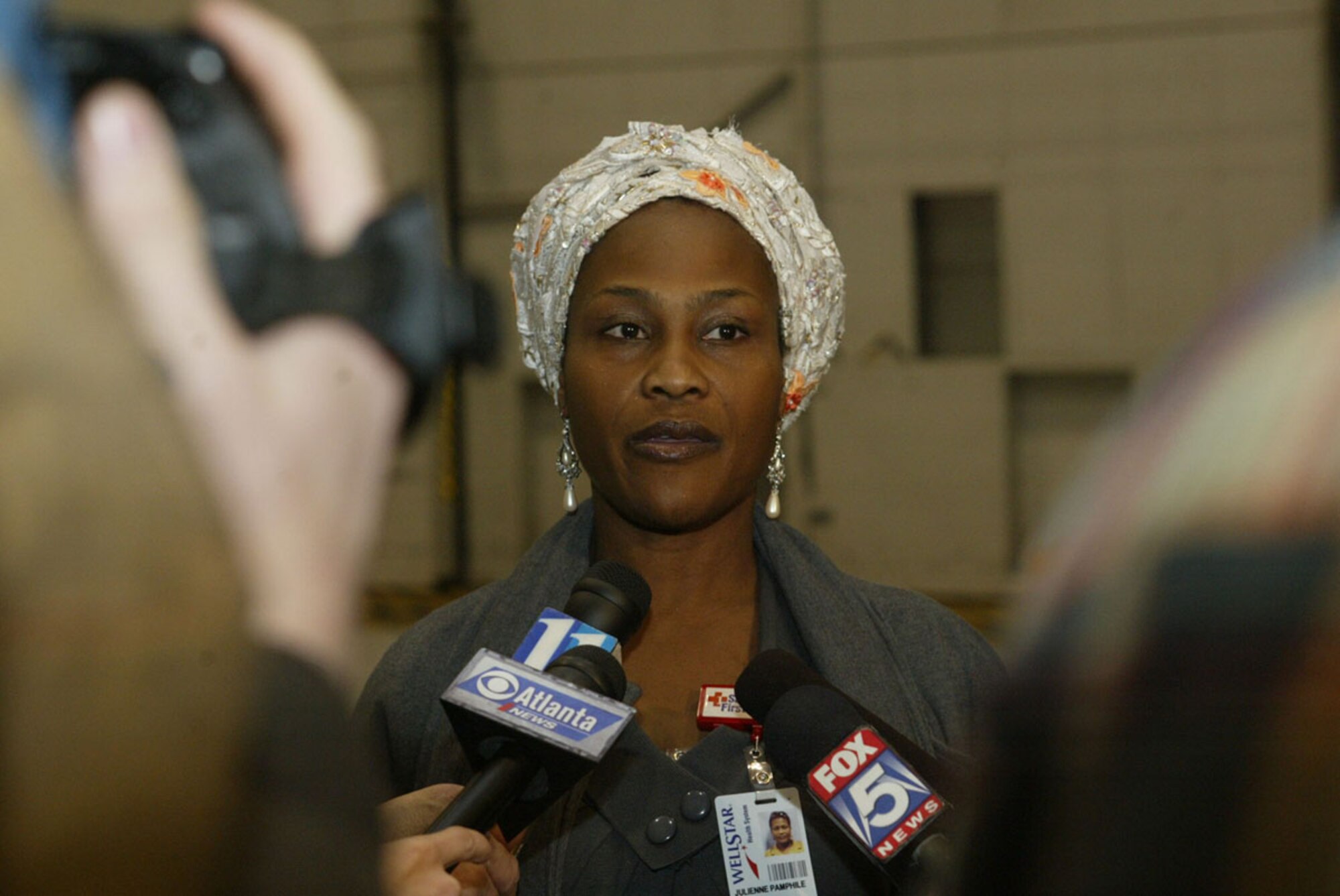 Despite her personal tragedy and the loss of six members of her family in the Haiti earthquake, Julienne Pamphile speaks to members of the media about her role as an interpreter between injured Haitians and local medical personnel Feb. 2. Half a dozen injured Haitians were flown into Dobbins Air Reserve Base on a C-130 aircraft late Feb. 2 and transported to local hospitals for urgent care. (U.S. Air Force photo/Don Peek)  