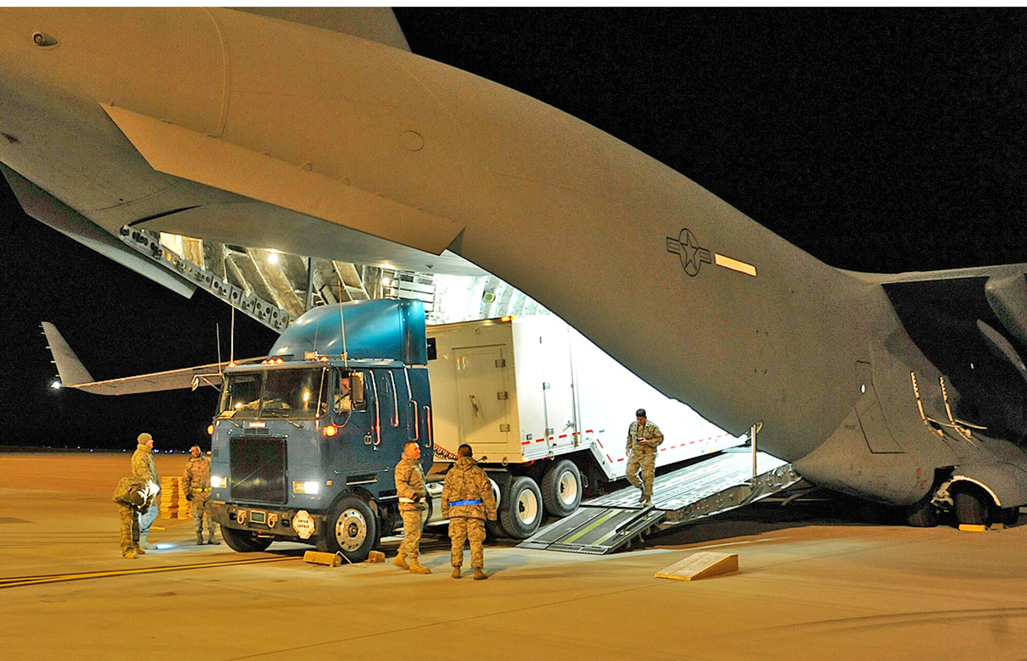 PETERSON AIR FORCE BASE, Colo. – Airmen from the 21st Logistics Readiness Squadron, working with Air Force Operational Test and Evaluation Center Detachment 4 Airmen, conduct a practice run of loading an Antenna Calibration Facility System into a C-17 Globemaster II Jan. 14 here. It was a tight squeeze, however the ACF System fit into the aircraft once Airmen let out air from the tires of the tractor trailer. The exercise was conducted to determine airlift suitability of the system. (Air Force photo by Rob Bussard)
