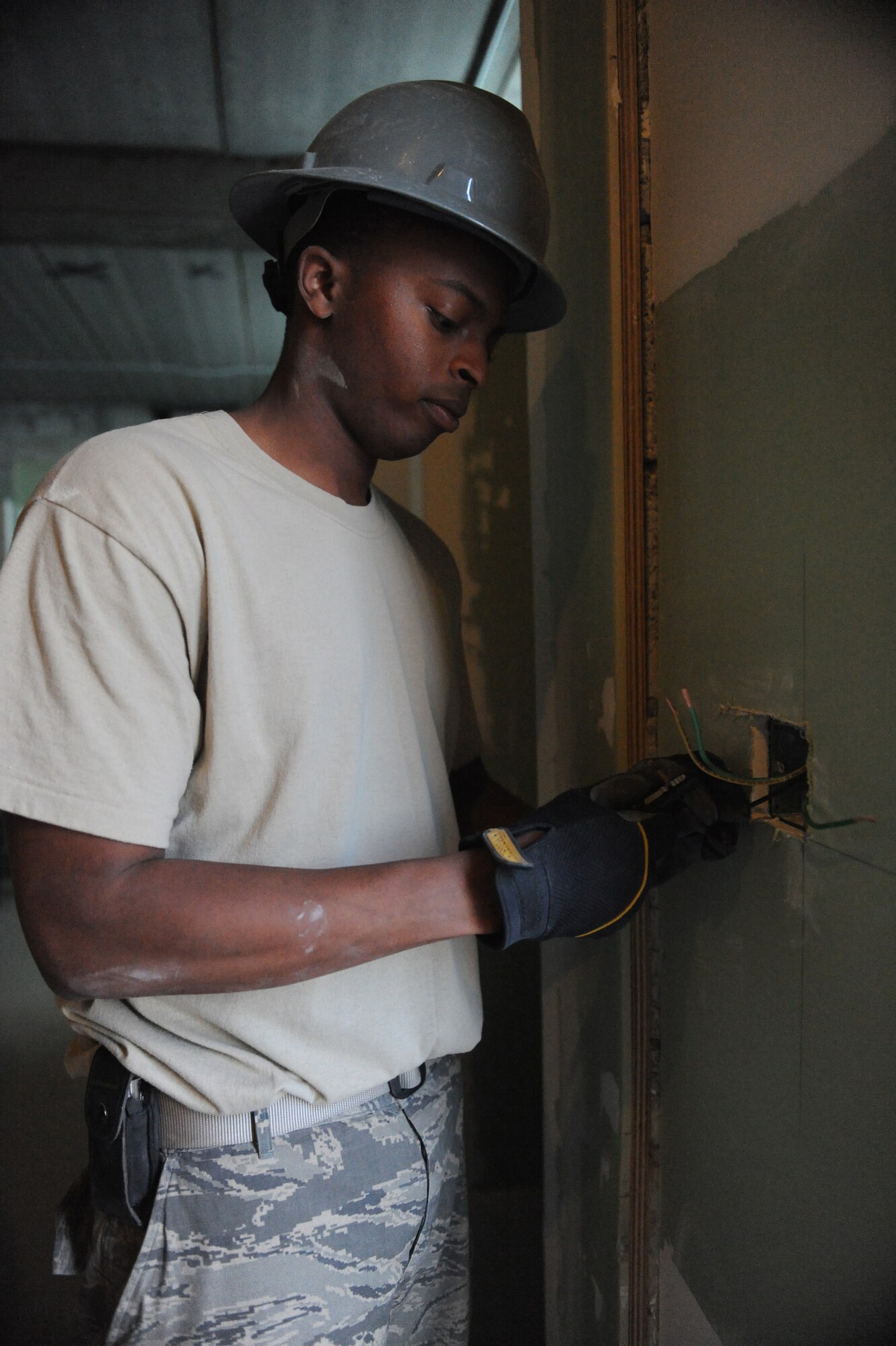 Staff Sgt. Corey Jones, 379th Expeditionary Civil Engineer Squadron electrical systems craftsman, strips cable prior to installing an outlet at a bunker cadillac bathroom under construction at a non-disclosed Southwest Asia location, Jan. 27, 2010. (U.S. Air Force photo by Tech. Sgt. Michelle Larche)[RELEASED]