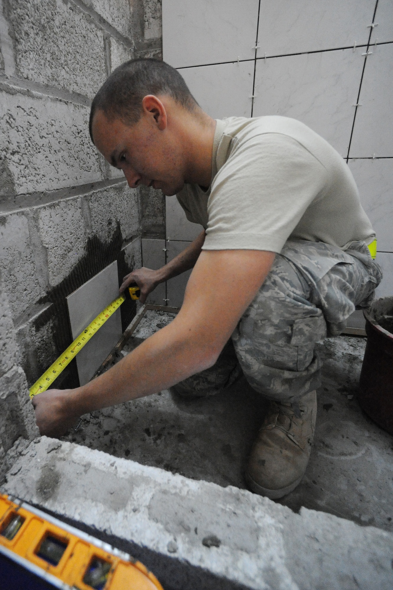 Airman 1st Class William Lloyd, 379th Expeditionary Civil Engineer Squadron structural apprentice, measures an area before applying new tile to a bunker cadillac bathroom under construction at a non-disclosed Southwest Asia location, Jan. 27, 2010. (U.S. Air Force photo by Tech. Sgt. Michelle Larche)[RELEASED]