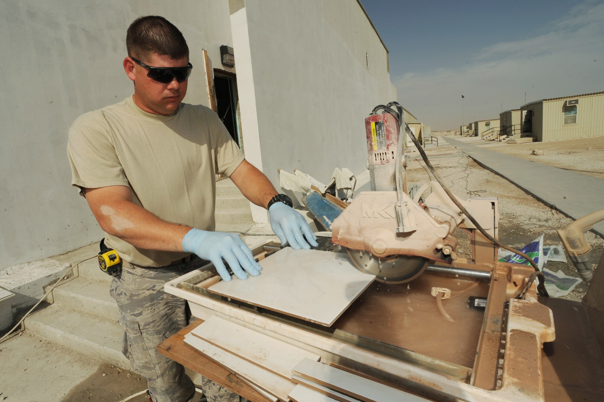 Staff Sgt. Chad Shaw, 379th Expeditionary Civil  Engineer Squadron structural craftsman, cuts tile to be installed in new bunker cadillac bathrooms at a non-disclosed Southwest Asia location, Feb. 01, 2010. (U.S. Air Force photo by Tech. Sgt. Michelle Larche)[RELEASED]