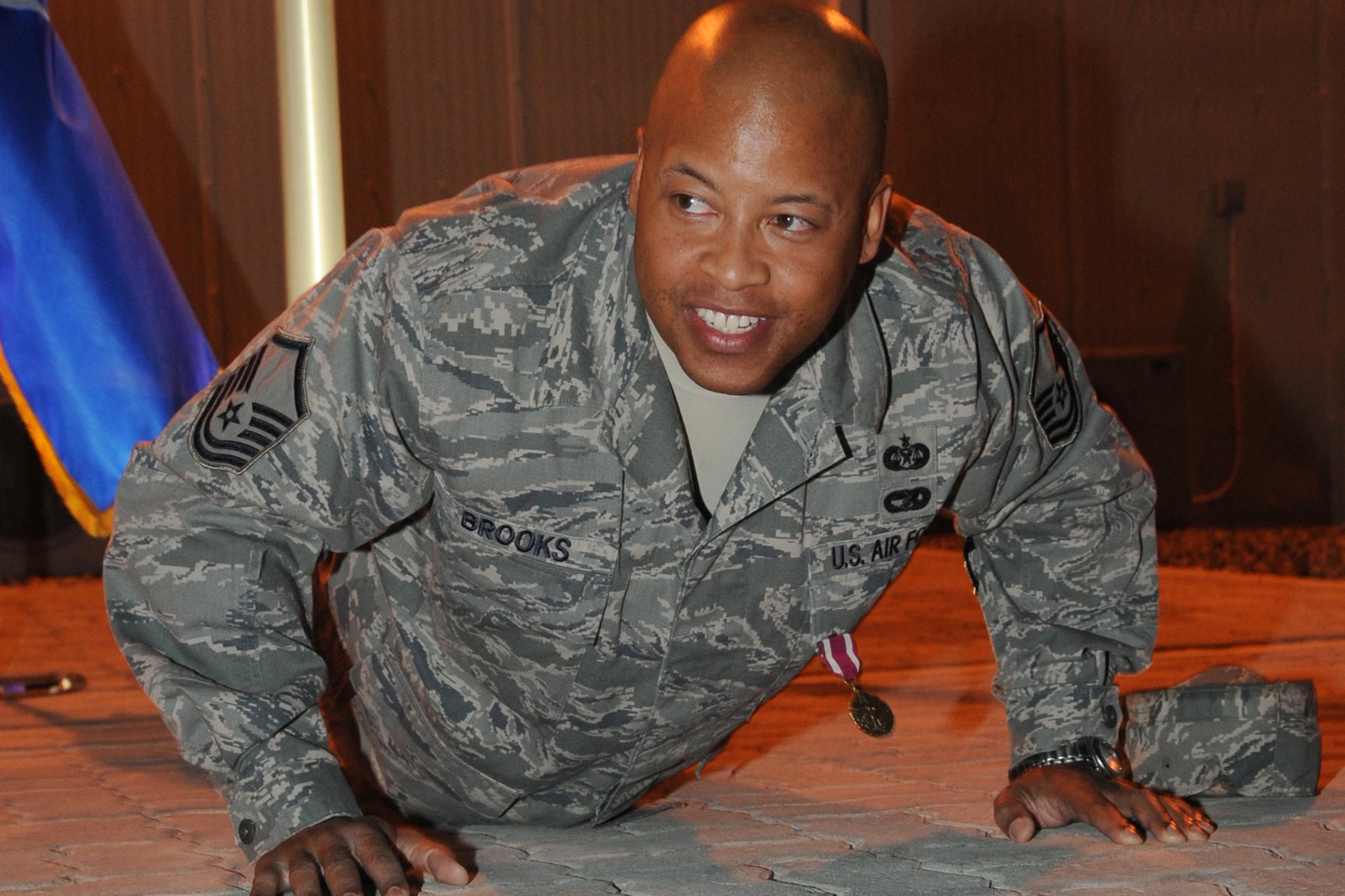 Master Sgt. Shawn Brooks, 380th Air Expeditionary Wing law office superintendent and non-commissioned officer in charge of honor guard, does push ups with members of the 380th AEW honor guard and wing staff agency during his awards presentation at an undisclosed location in Southwest Asia on Feb. 2, 2010. Sergeant Brooks has been the NCOIC of the honor guard since November and has created an operating instruction, honor guard contract and standardized training. Members of the honor guard traditionally do push ups after each practice twice a week. Sergeant Brooks hails from Brooklyn, N.Y. and is deployed from Air Education Training Command Headquarters legal office Randolph Air Force Base, Texas, where he is the law office manager. (U.S. Air Force photo/Senior Airman Jenifer H. Calhoun/Released)
