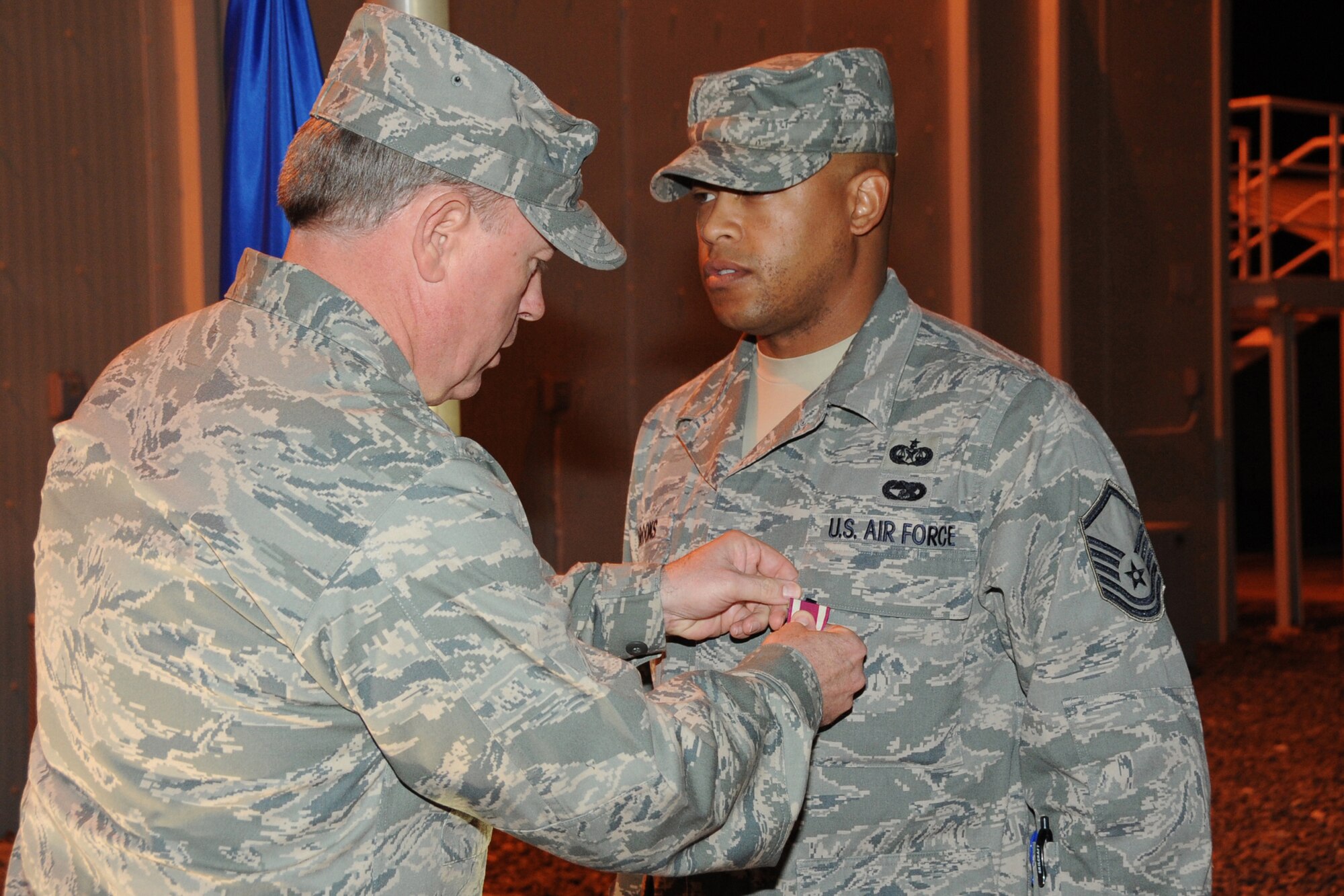 Master Sgt. Shawn Brooks,380th Air Expeditionary Wing law office superintendent and non-commissioned officer in charge of honor guard, receives the meritorious service medal during his awards presentation from Brig. Gen. Bryan Benson, 380th AEW commander, at an undisclosed location in Southwest Asia on Feb 2, 2010. Sergeant Brooks has been the NCOIC of the honor guard since November and received a  flag, wing coin and chief's coin for his dedication and service to the honor guard and within the legal office. Sergeant Brooks hails from Brooklyn, N.Y and is deployed from Air education Training Command Headquarters legal office Randolph Air Force Base, Texas, where he is the law office manager. (U.S. Air Force photo/Senior Airman Jenifer H. Calhoun/Released)
