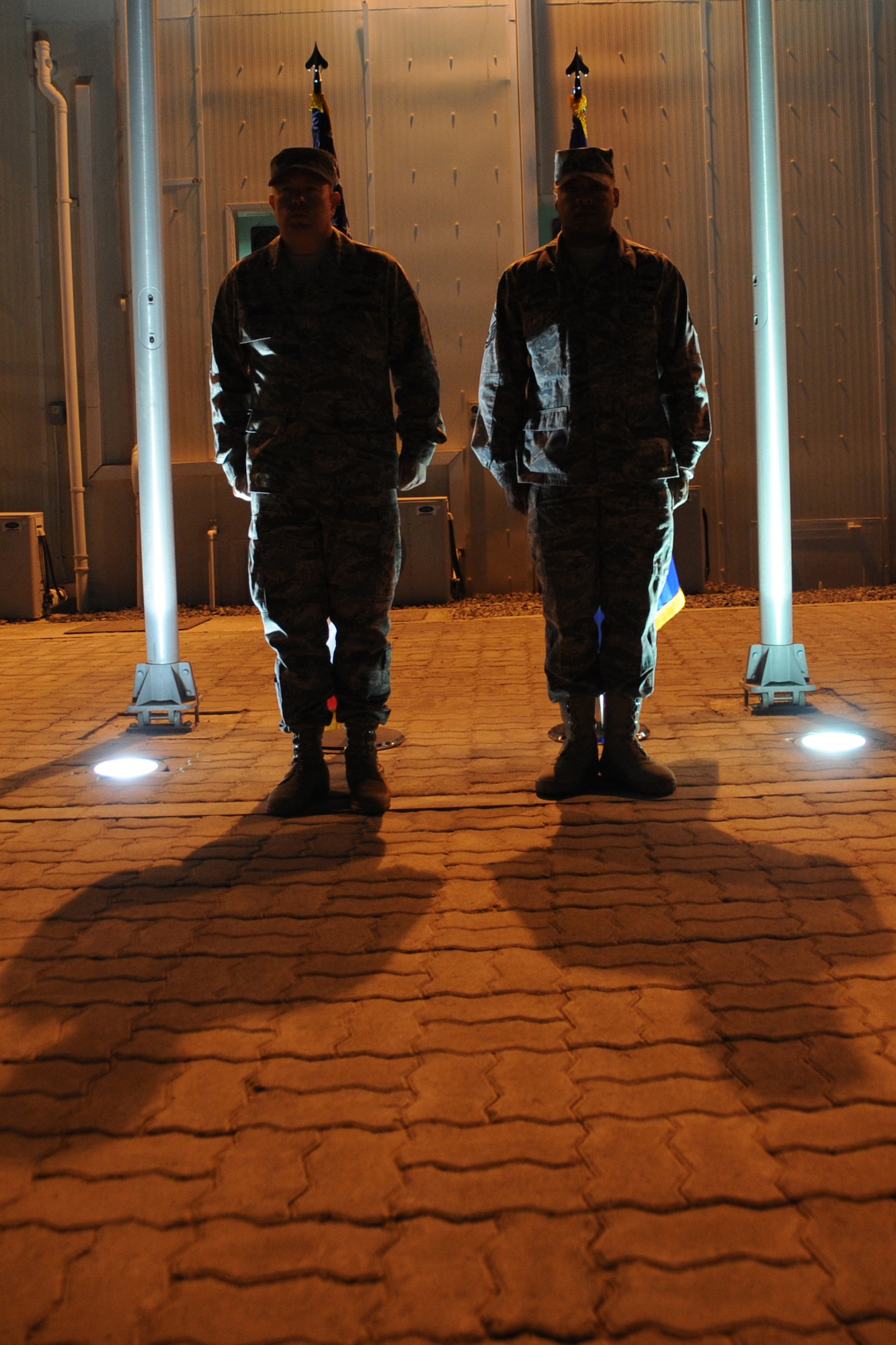 Brig. Gen. Bryan Benson, 380th Air Expeditionary Wing Commander, stands at attention with Master Sgt. Shawn Brooks, law office superintendent and non-commissioned officer in charge of honor guard, as Sergeant Brook's award citation is read during his awards presentation at an undisclosed location in Southwest Asia on Feb. 2, 2010.  Sergeant Brooks has been the NCOIC of the honor guard since Nov. and has created an operating instruction, honor guard contract and standardized training. Sgt. Brooks hails from Brooklyn, N.Y. and is deployed from Air education Training Command Headquarters legal office Randolph Air Force Base, Texas, where he is the law office manager. (U.S. Air Force photo/Senior Airman Jenifer H. Calhoun/Released)
