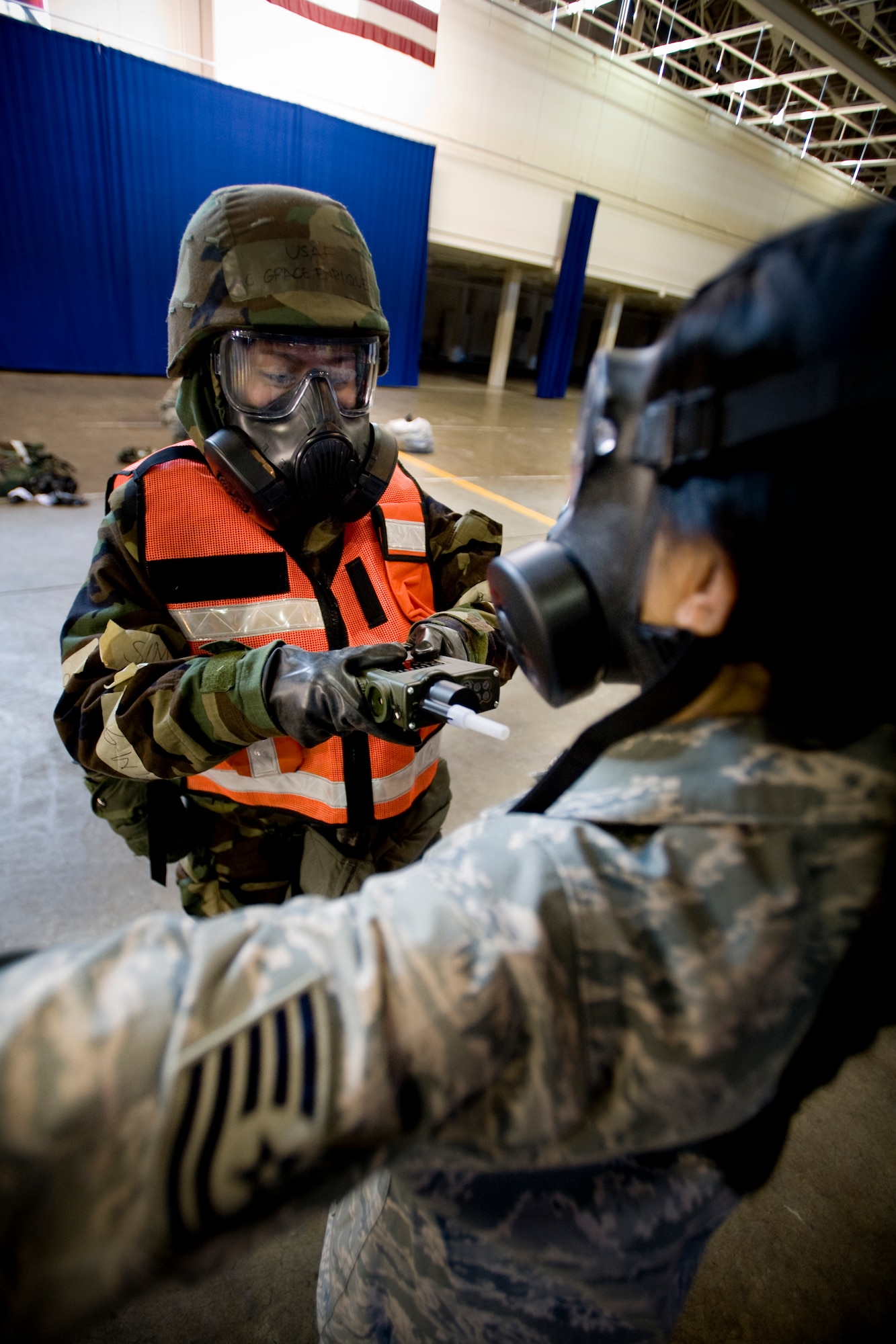 MISAWA AIR BASE, Japan -- Airman 1st Class Grace Enriquez, 35th Communications Squadron systems control technician, scans for toxics on Tech. Sgt. Maria Caraballo, 35th Logistics Readiness Squadron NCO in charge of deployments, Feb. 3 at a simulated contamination control area. The scan was one of the last steps completed before Airmen could safely remove their masks. (U.S. Air Force photo/Senior Airman Jamal D. Sutter)