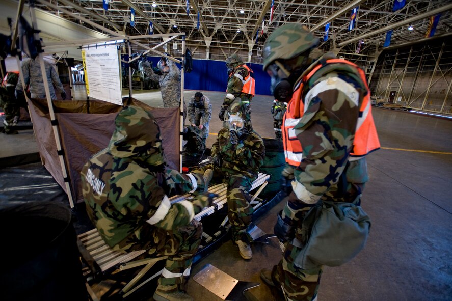 MISAWA AIR BASE, Japan -- Airmen remove each other's overboots Feb. 3 at a simulated contamination control area during an operational readiness exercise. Contamination control areas allow personnel to remove surface contamination and move to an area free of toxics. (U.S. Air Force photo/Senior Airman Jamal D. Sutter)