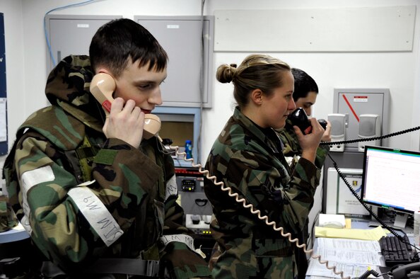 MISAWA AIR BASE, Japan -- Airmen 1st Class Richard Kelly, Stephanie Tyrolt and Senior Airman Timothy Mercado, emergency action controllers, 35th Fighter Wing Command Post, answer phones and communicate on the public address system Feb. 3 during an exercise. The command post serves as the command and control headquarters during exercises and real-world situations. (U.S. Air Force photo/Staff Sgt. Chad C. Strohmeyer)