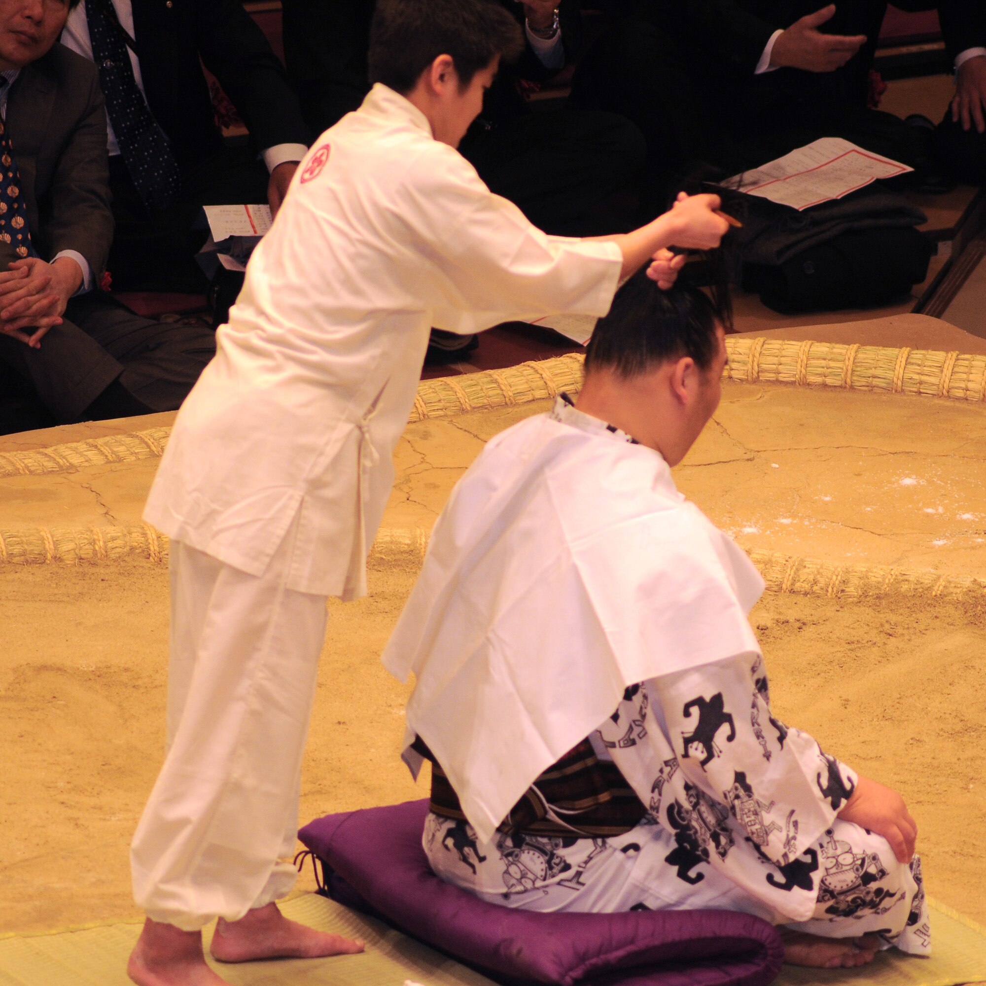 TOKYO -- A sumo hair stylist demonstrates how to create a traditional sumo hairstyle at the Ryogoku Kokugikan "arena"  Jan. 31.  Amzumazwki-beya, a local Japanese sumo-training center, invited more than 600 students, parents and teachers from Yokota Air Base to experience this Japanese tradition. (U.S. Air Force photo/Airman 1st Class Katrina Menchaca)