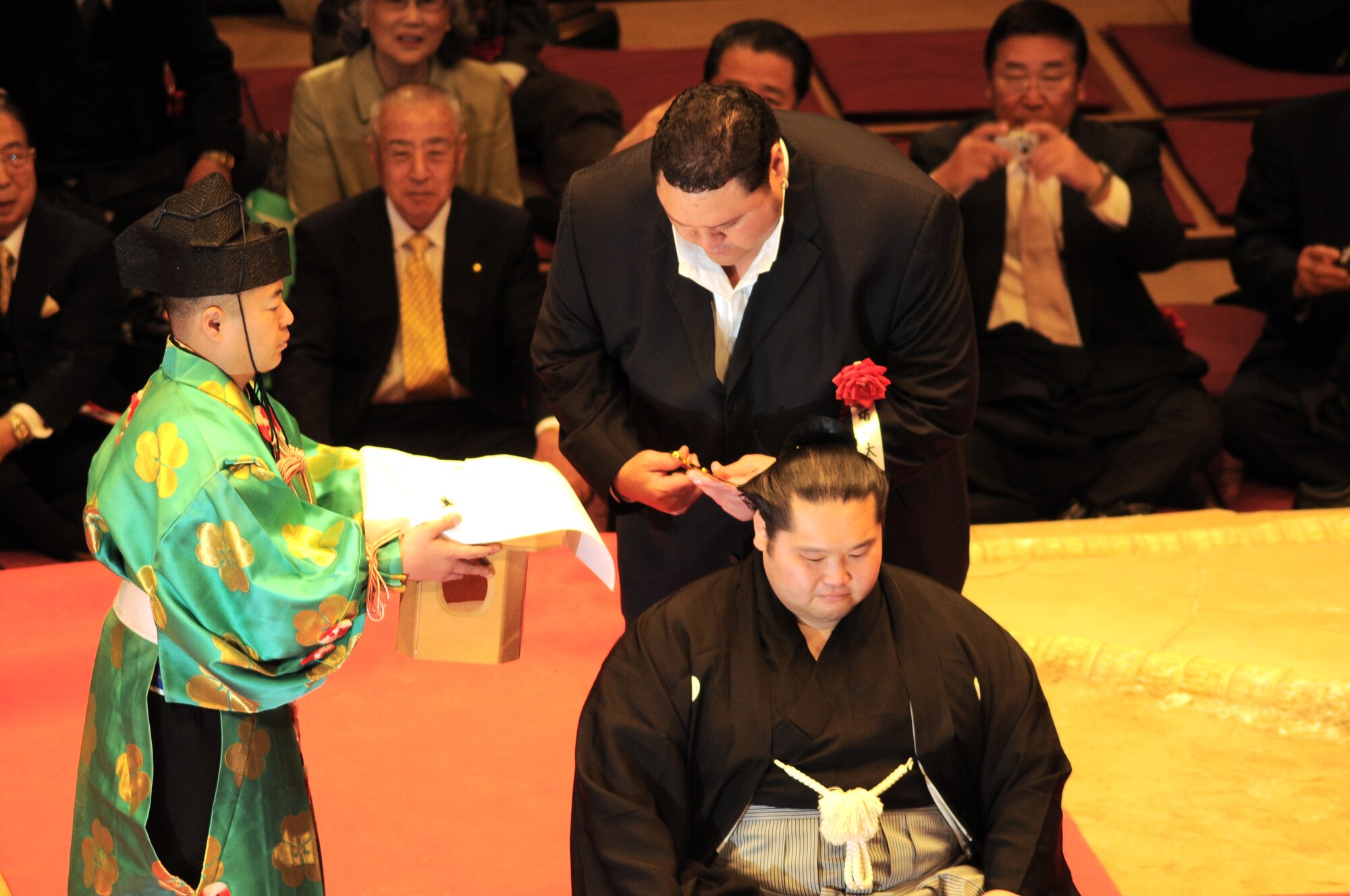 TOKYO -- Akebono Taro, a retired sumo wrestler, cuts sumo wrestler  Ushiomaru Motoyasu's hair as part of his retirement ceremony at the Ryogoku Kokugikan "arena" Jan. 31. Amzumazwki-beya, a local Japanese sumo-training center, invited more than 600 students, parents and teachers from Yokota Air Base to experience this Japanese tradition. (U.S. Air Force photo/Airman 1st Class Katrina Menchaca)