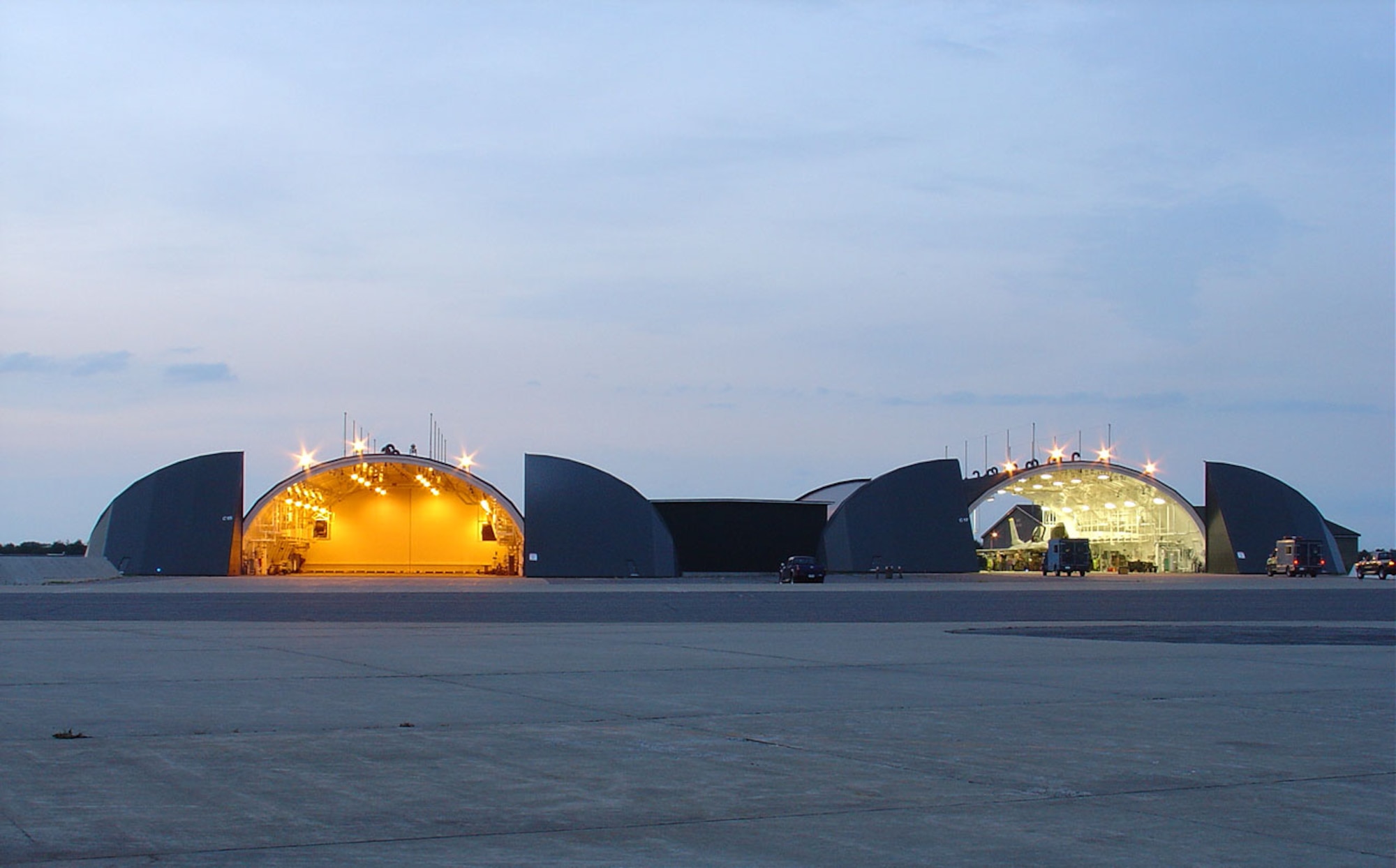 Pictured on the left is a hangar at Misawa Air Base, Japan, featuring high intensity discharge light fixtures which are being replaced by high output fluorescent fixtures recently installed in the hangar on the right. Kadena installed similar lighting fixtures in more 40 base facilities in an effort to reduce energy consumption on base. (Courtesy photo)