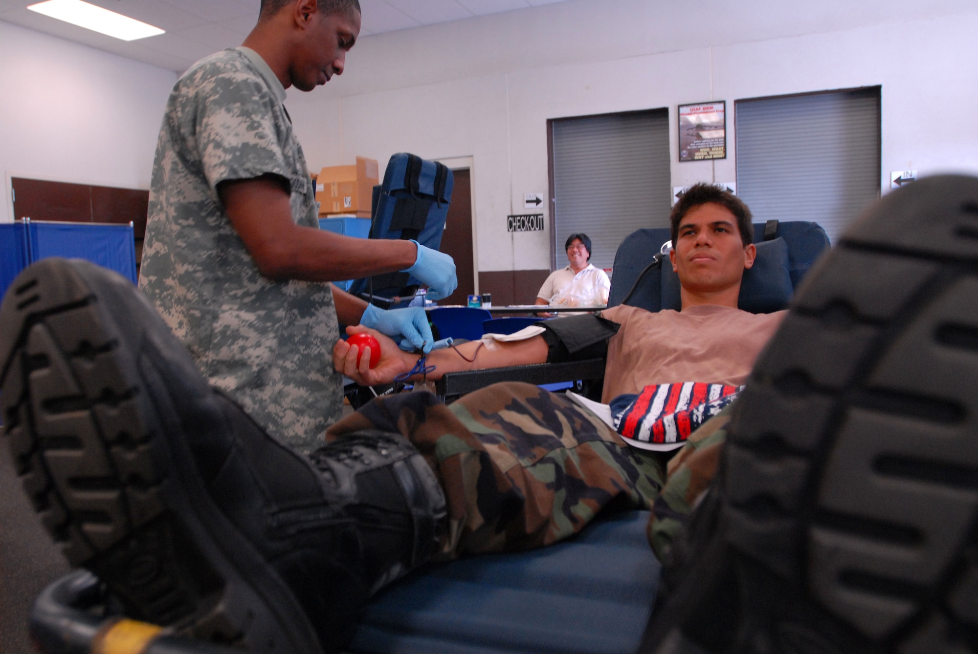 JOINT BASE PEARL HARBOR HICKAM, Hawaii - Specialist Christopher Goodman, Tripler Army Medical Center lab technician, retrieves blood from Staff Sgt. James Chun, 154th Maintenance Squadron crew chief during a blood drive here, Feb. 4. Blood donations made will be used for patients in Haiti, Iraq, and Afghanistan. TAMC projects 30-40 pints of blood for the day. (U.S. Air Force photo/Senior Airman Gustavo Gonzalez)