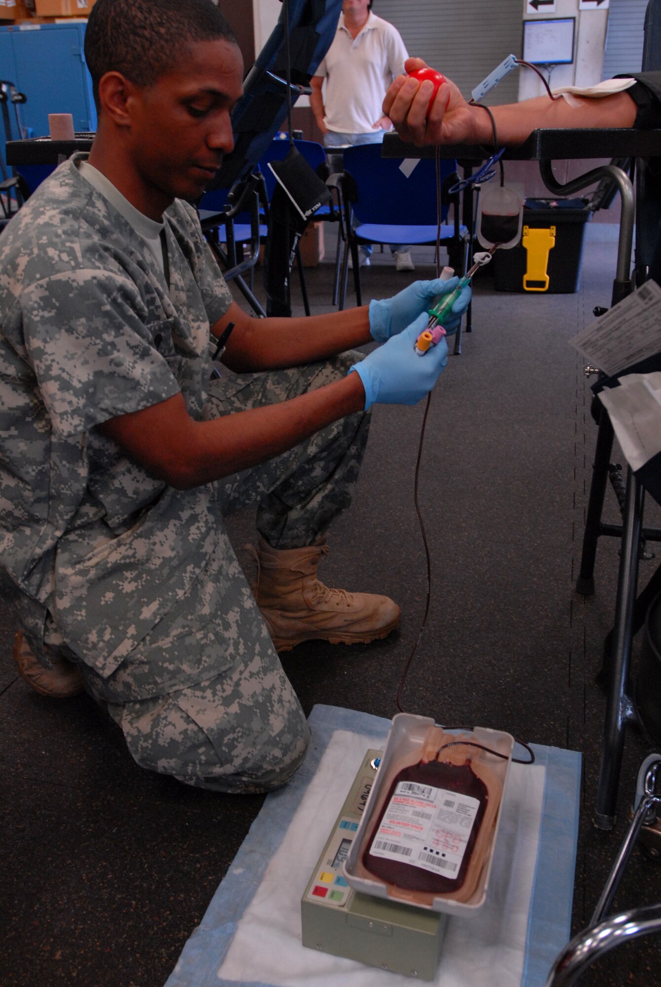 JOINT BASE PEARL HARBOR HICKAM, Hawaii - Specialist Christopher Goodman, Tripler Army Medical Center lab technician, retrieves blood from a bag during a blood drive here, Feb. 4.Blood donations made will be used for patients in Haiti, Iraq, and Afghanistan. TAMC projects 30-40 pints of blood for the day. (U.S. Air Force photo/Senior Airman Gustavo Gonzalez)