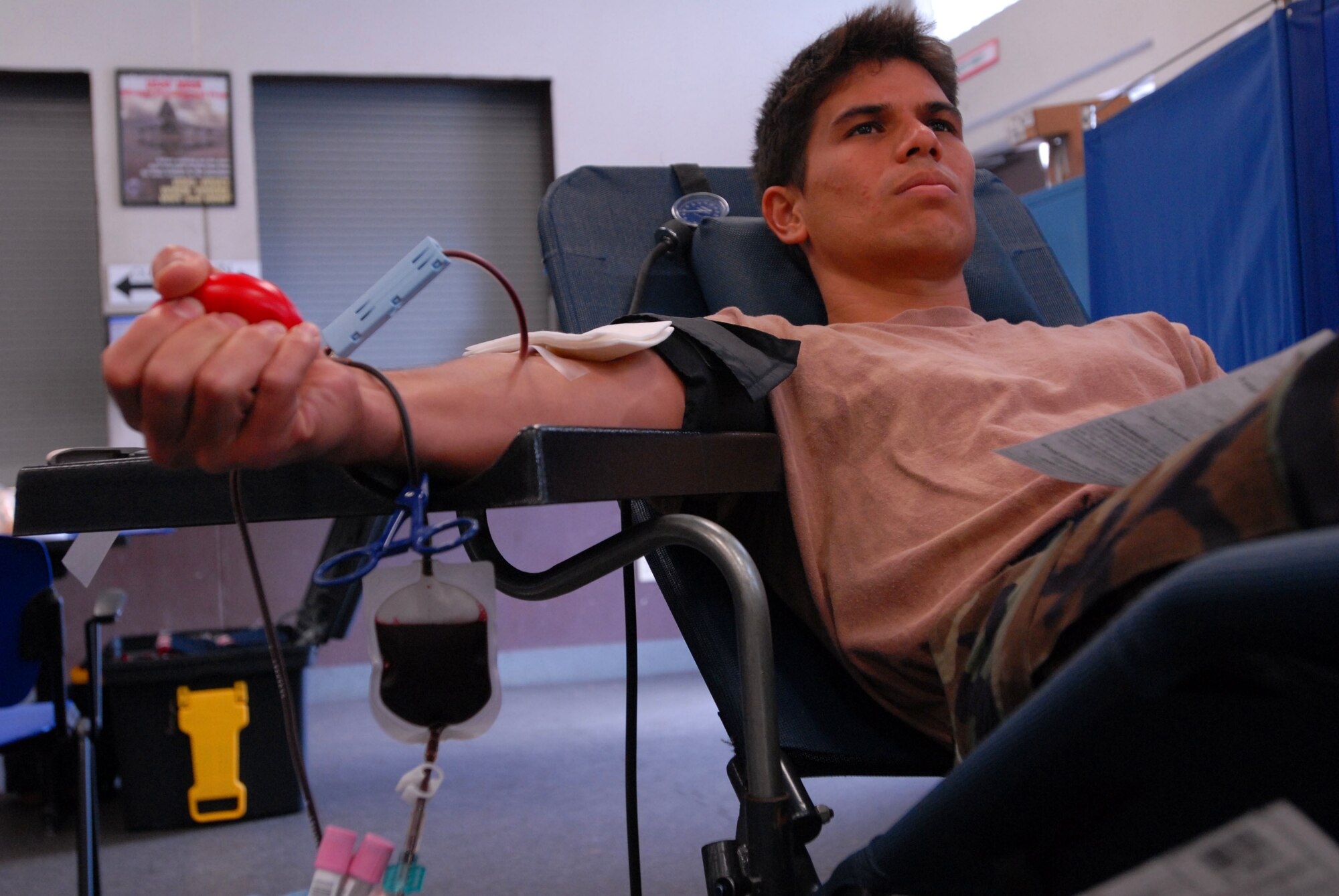 JOINT BASE PEARL HARBOR HICKAM, Hawaii - Staff Sgt. James Chun, 154th Maintenance Squadron crew chief, sqeezes a ball while pumping blood into a bag during a blood drive here, Feb. 4. Blood donations made will be used for patients in Haiti, Iraq, and Afghanistan. Tripler Army Medical Center projects 30-40 pints of blood for the day. (U.S. Air Force photo/Senior Airman Gustavo Gonzalez)