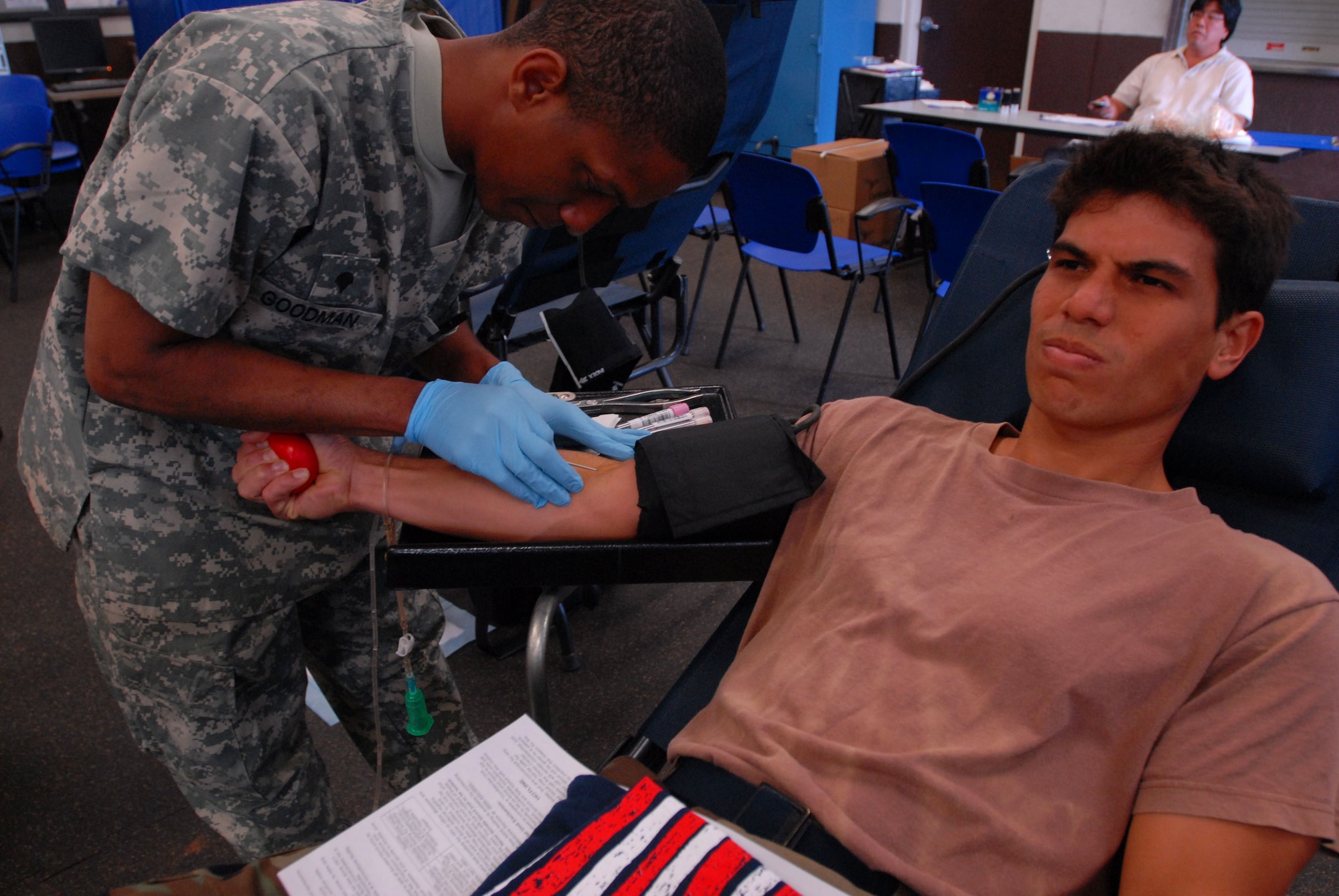JOINT BASE PEARL HARBOR HICKAM, Hawaii - Staff Sgt. James Chun, 154th Maintenance Squadron crew chief, cringes as Specialist Christopher Goodman, Tripler Army Medical Center lab technician, retrieves blood from his right arm here, Feb. 4. Blood donations made will be used for patients in Haiti, Iraq, and Afghanistan. TAMC projects 30-40 pints of blood for the day. (U.S. Air Force photo/Senior Airman Gustavo Gonzalez)
