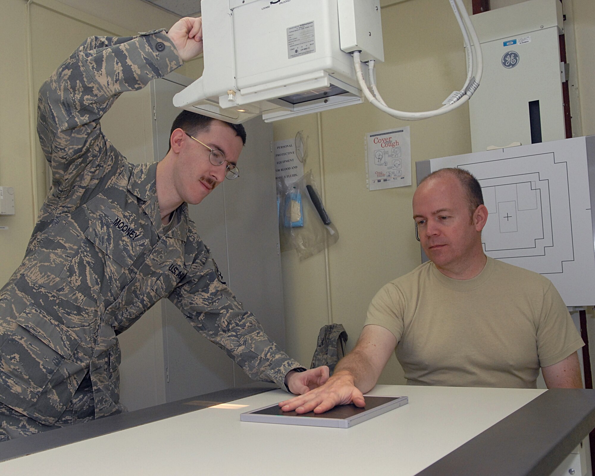 KUNSAN AIR BASE, Republic of Korea -- Staff Sgt. Joseph Mooney, 8th Medical Support Squadron diagnostic imaging technician, positions Tech. Sgt. Roger Heshiser, also an 8th Medical Support Squadron diagnostic imaging technician, hand for an X-ray at the base clinic Feb. 4. Kunsan Diagnostic Imaging Technicians operate radiographic equipment to produce diagnostic medical images. (U.S. Air Force photo/Senior Airman Roy Lynch)