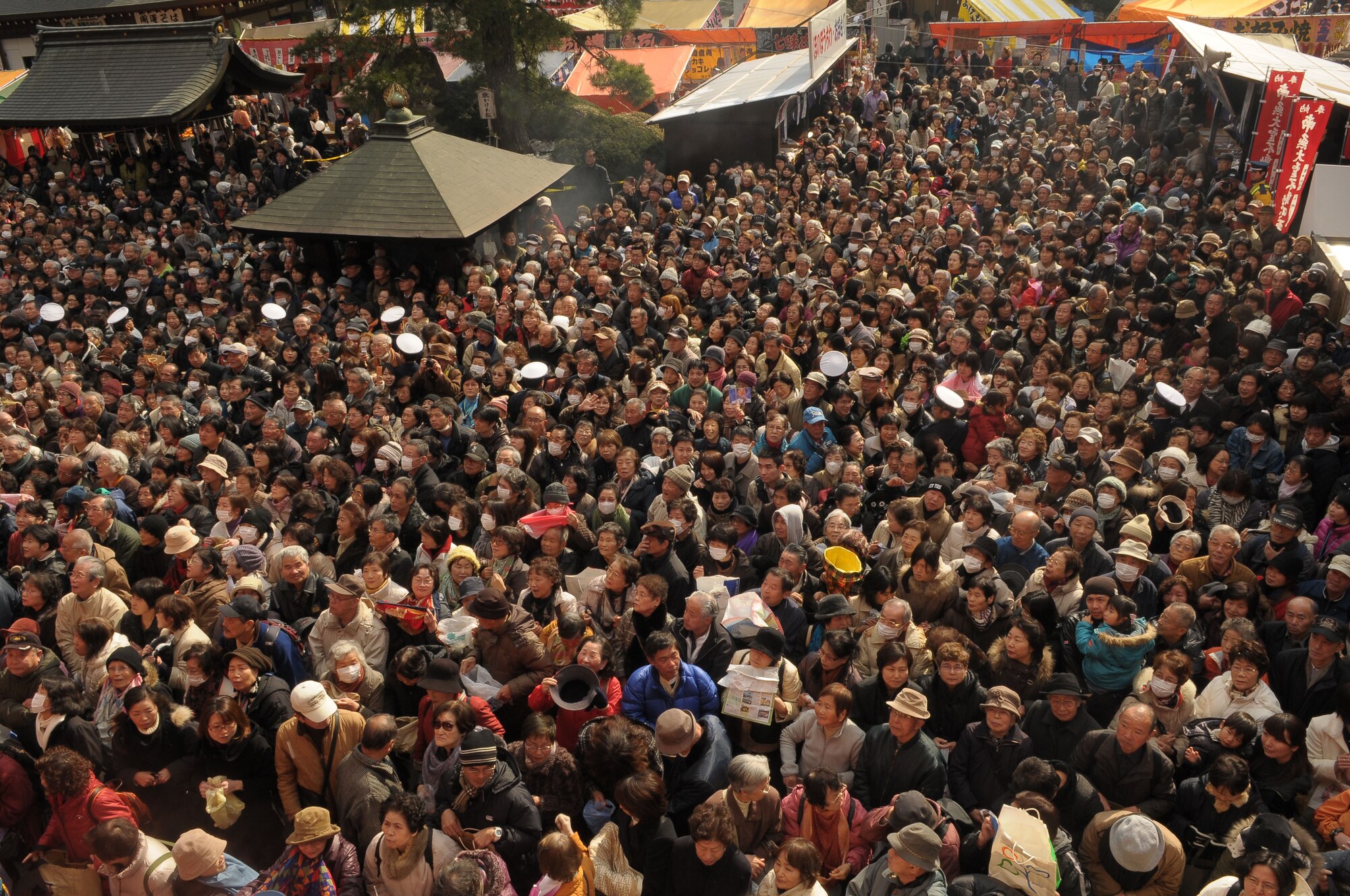 HINO, Japan -- A crowd gathers in hopes of catching soy beans during the bean throwing ceremony at Takahata FudoTemple Feb. 3. During the ceremony, people throw roasted soybeans while shouting "Fu ku wa uchi" which means, "Come in happiness". It is believed that if you eat the number of beans equal to your age, you will have a happy and healthy life. (U.S. Air Force photo/Airman 1st Class Sean Martin)