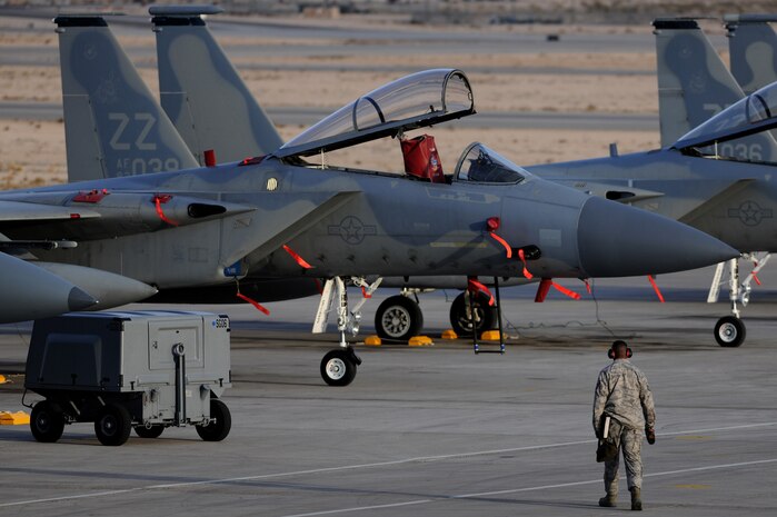 NELLIS AIR FORCE BASE, Nev. -- A crew chief assigned the 18th Aircraft Maintenance Squadron, walks toward a row 44th Fighter Squadron F-15's to perform pre-flight inspections at Red Flag 10-2  Feb. 2, 2010.  Red Flag is a realistic combat training exercise involving the air forces of the United States and its allies. The exercise is conducted on the 15,000-square-mile Nevada Test and Training Range, north of Las Vegas. (U.S. Air Force photo by Tech. Sgt. Michael R. Holzworth/RELEASED)