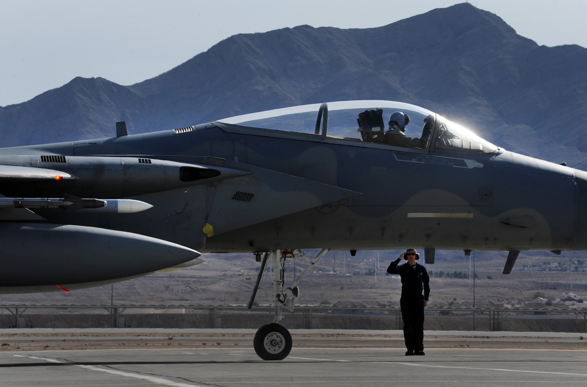 NELLIS AIR FORCE BASE, Nev. -- Senior Airman Kevin Sarginger, 18th Aircraft Maintenance Squadron, Kadena Air Base, Japan, salutes as his F-15 Eagle departs for a training mission at Red Flag 10-2, Nellis Air Force Base, Nev., Feb. 2, 2010.  Red Flag is a realistic combat training exercise involving the air forces of the United States and its allies. The exercise is conducted on the 15,000-square-mile Nevada Test and Training Range, north of Las Vegas. (U.S. Air Force photo by Tech. Sgt. Michael R. Holzworth/RELEASED)