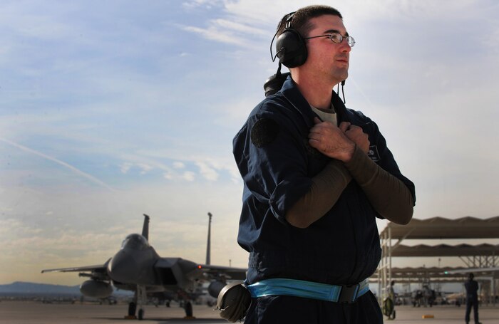 NELLIS AIR FORCE BASE, Nev. -- Senior Airman Jonathan Deem, 18th Aircraft Maintenance Squadron, Kadena Air Base, Japan, tells the pilot to hold by using hand signals before launching his F-15 Eagle on a training mission at Red Flag 10-2, Nellis Air Force Base, Nev., Feb. 2, 2010.  Red Flag is a realistic combat training exercise involving the air forces of the United States and its allies. The exercise is conducted on the 15,000-square-mile Nevada Test and Training Range, north of Las Vegas. (U.S. Air Force photo by Tech. Sgt. Michael R. Holzworth/RELEASED)