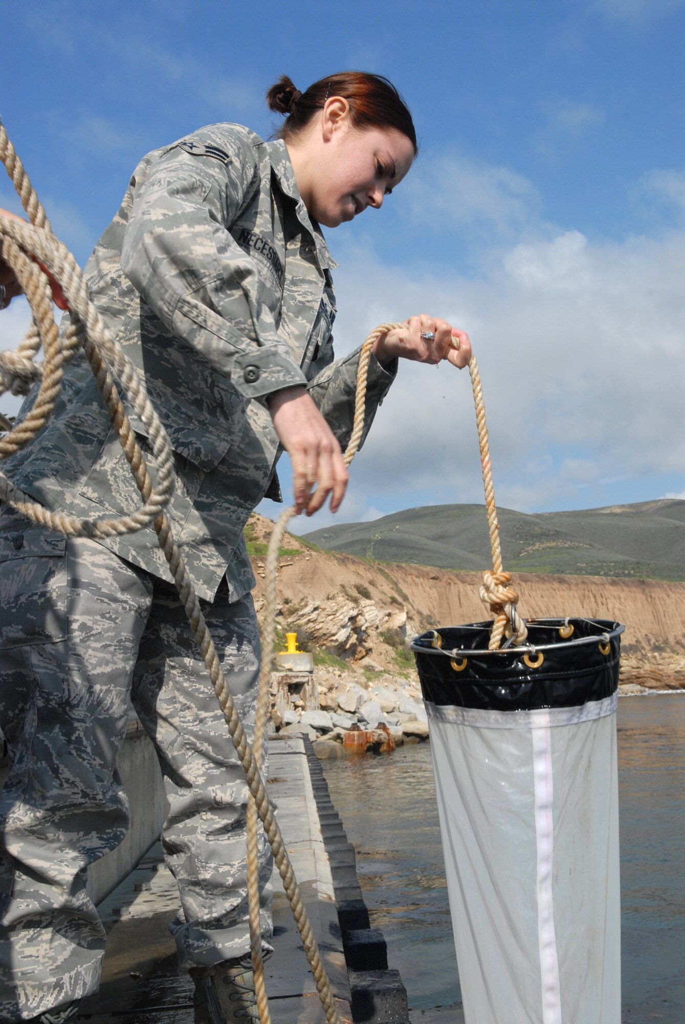 VANDENBERG AIR FORCE BASE, Calif. -- Reeling in the water sampling net and canister, Airman 1st Class Megan Necessary of the 30th Medical Operations Squadron Public Health office prepares for a second try at casting the net out to sample ocean water here Tuesday, Feb. 2, 2010. Due to the complications of air bubbles making the equipment float to the surface, many attempts may be needed to get the canister to the necessary depth of 10 feet in order to get adequate samples. (U.S. Air Force photo/Airman 1st Class Angelina Drake)
