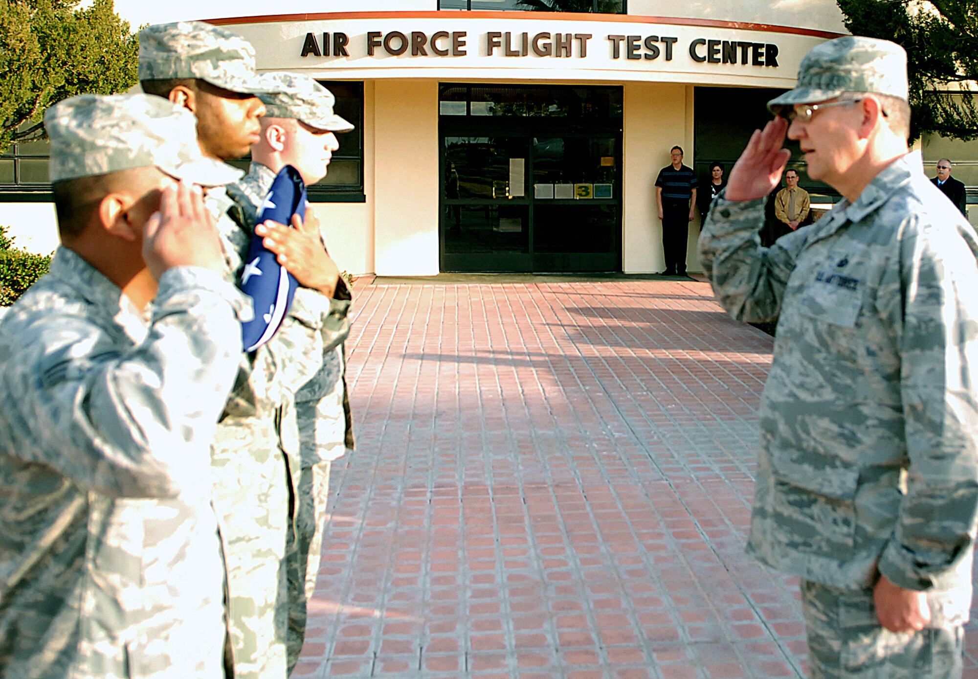 Airmen present Col. Paul Hardy, 95th Communications Group commander, with the American Flag following a retreat ceremony in front of the Air Force Flight Test Center Headquarters Feb. 2. A retreat ceremony marks the end of the duty day and honors the American Flag. (Air Force photo/Airman 1st Class William O'Brien)