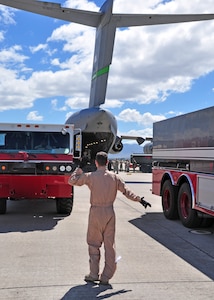 A loadmaster guides the first of two fire trucks toward a 62nd Airlift Wing C-17 out of McChord Air Force Base, Wash. Feb. 3 at Soto Cano Air Base, Honduras. The Soto Cano fire trucks are bound for the Port-au-Prince International Airport in Haiti in support of Operation Unified Response. (U.S. Air Force Photo/Staff Sgt. Bryan Franks)