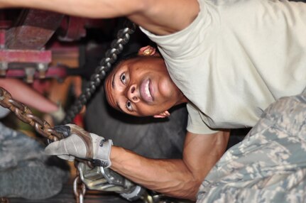 Staff Sgt. Tameek Valentine, 612th Air Base Squadron, tightens down chains to secure one of two fire trucks Feb. 3 from Soto Cano Air Base, Honduras bound for Port-au-Prince International Airport in Haiti in support of Operation Unified Response. (U.S. Air Force Photo/Staff Sgt. Bryan Franks)