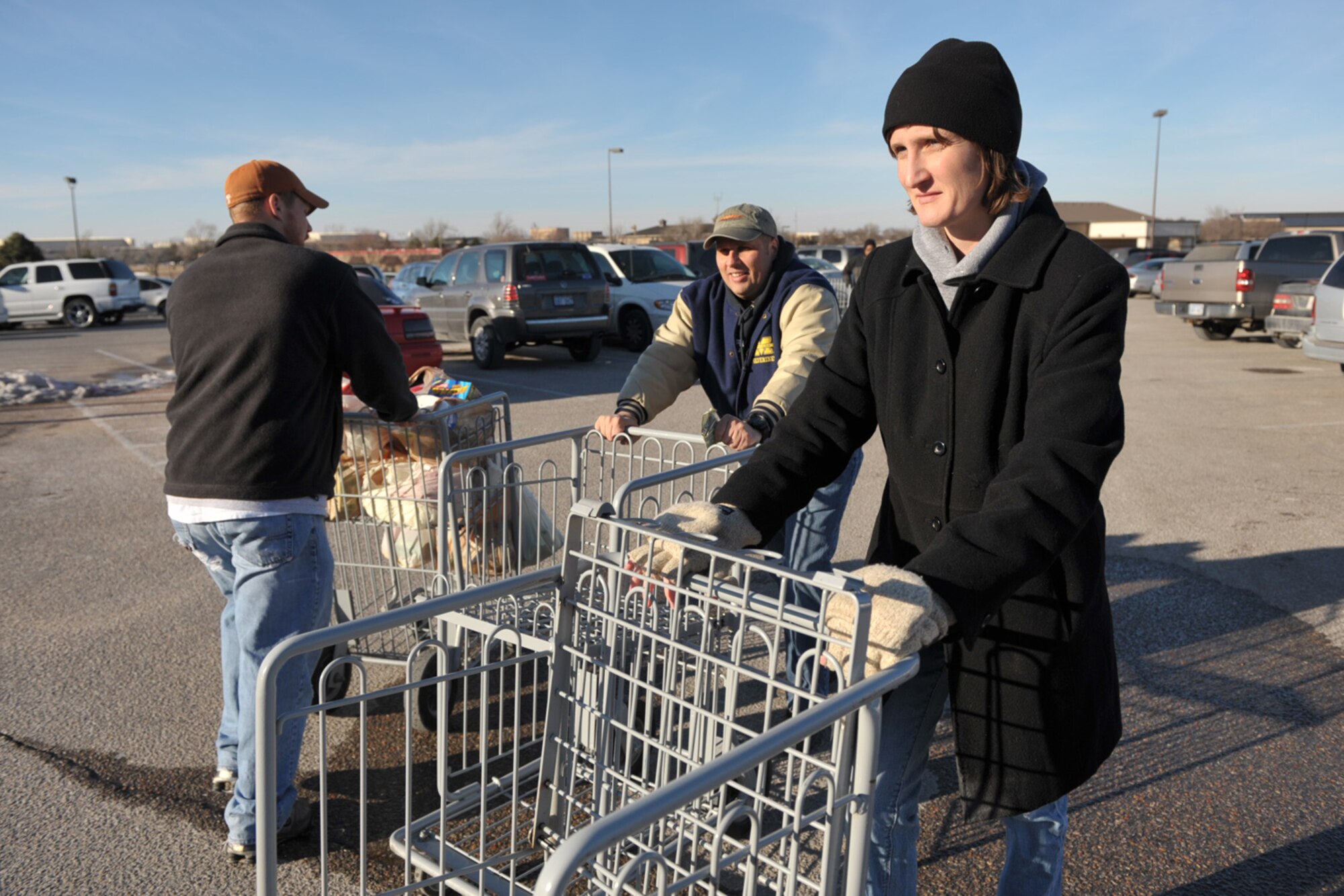 Tech. Sgt. Kevin Bouchard follows Maj. Leah Schmidt back to the commissary at McConnell Air Force Base, Kan., after helping a customer get groceries to her vehicle. They and other members of the 931st Air Refueling Group's Human Resource Development Council volunteered for duty during the 931st's last training assembly to help raise funds for the Council. Major Schmidt and Sergeant Bouchard are both Air Force Reservists assigned to the 18th Air Refueling Squadron, the flying unit of the 931st ARG. (U.S. Air Force photo/Master Sgt. Jason Schaap)