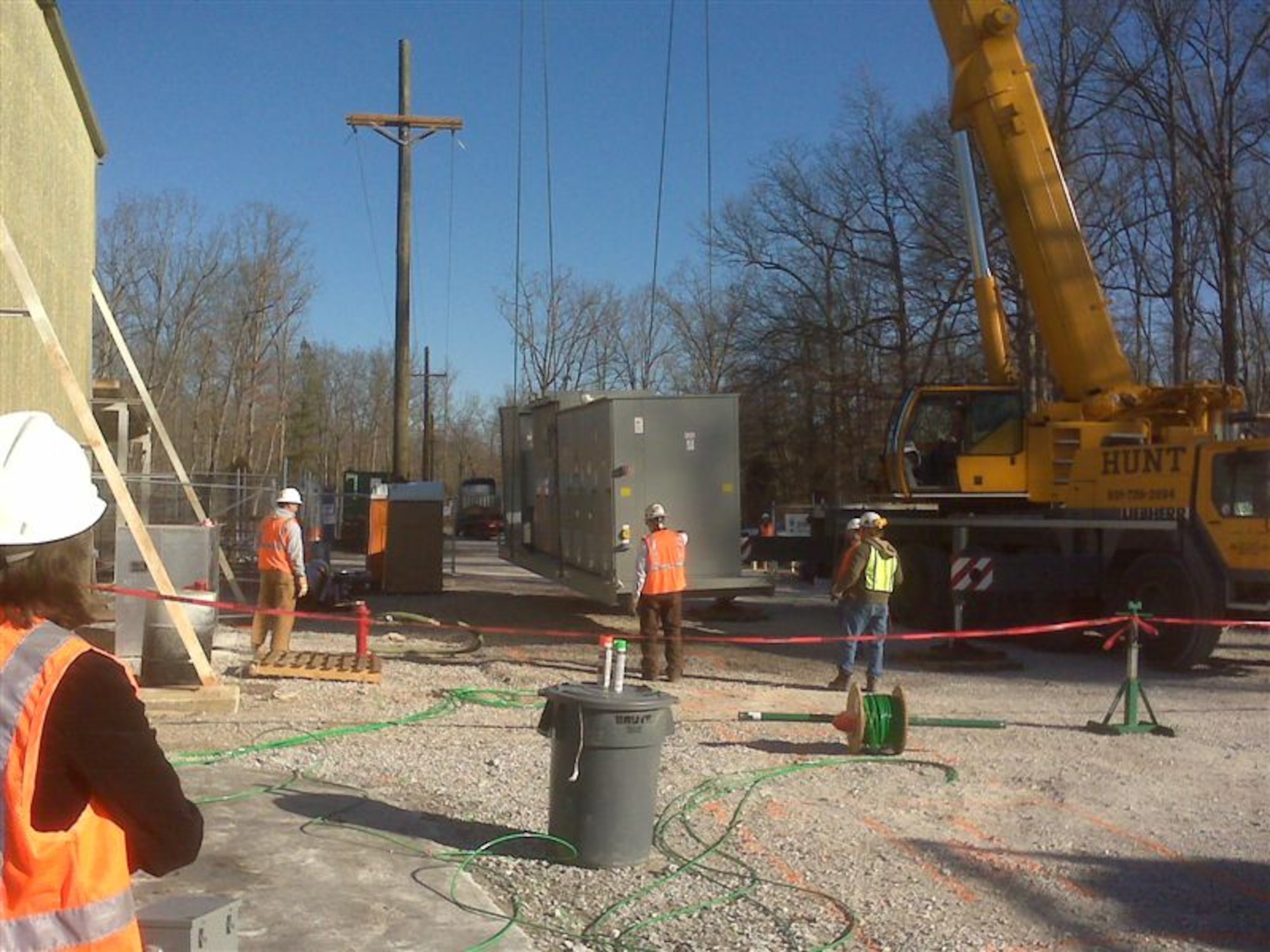 Employees from the main contractor, CH2MHill, and sub-contractor Terra-Therm provide assistance to the Dennis Hunt & Company crane guiding an electrical substation into place behind the Model Shop. This substation will soon power the thermal treatment remediation system being used to remove the PCE from this site. (Photos provided)