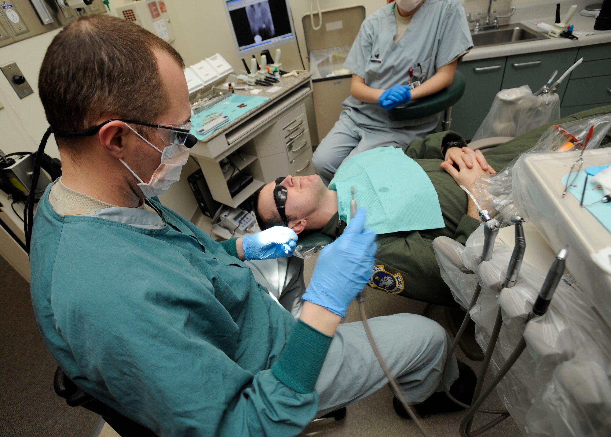 ELMENDORF AIR FORCE BASE, Alaska -- Capt. Anthony Mecham, 3rd Dental Squadron, examines a tooth cap before modifying it Feb. 3. Captain Mecham was completing a dental procedure where a patient needed a cap placed over a rotten tooth. (Air Force photo/ Senior Airman Matt Coleman-Foster)