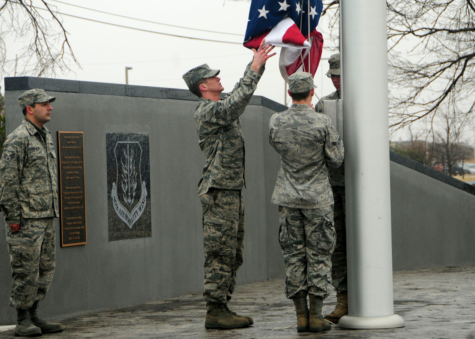 ALTUS AIR FORCE BASE, Okla. --  (From left) Senior Airman Raymond Salazar and Ryan Gava, Airman 1st Class Chris Schaaf, and Airman 1st Class Thomas Baszler raise the flag at the Wings of Freedom Park on Feb 3. A 1 1/2-inch thick coating of ice forced the base to take down the flag Jan. 28. The flag raising ceremony symbolizes the determination and resiliency of all Altus Airmen as they recover the base from the worst area storm in 62 years. Airman Salazar hails from the 97th Communications Squadron, Airman Gava is from the 97th Civil Engineering Squadron, and Airmen Schaaf and Baszler are both from the 97th Medical Operations Squadron. (U.S Air Force photo/Airman 1st Class Myles T. Stepp)