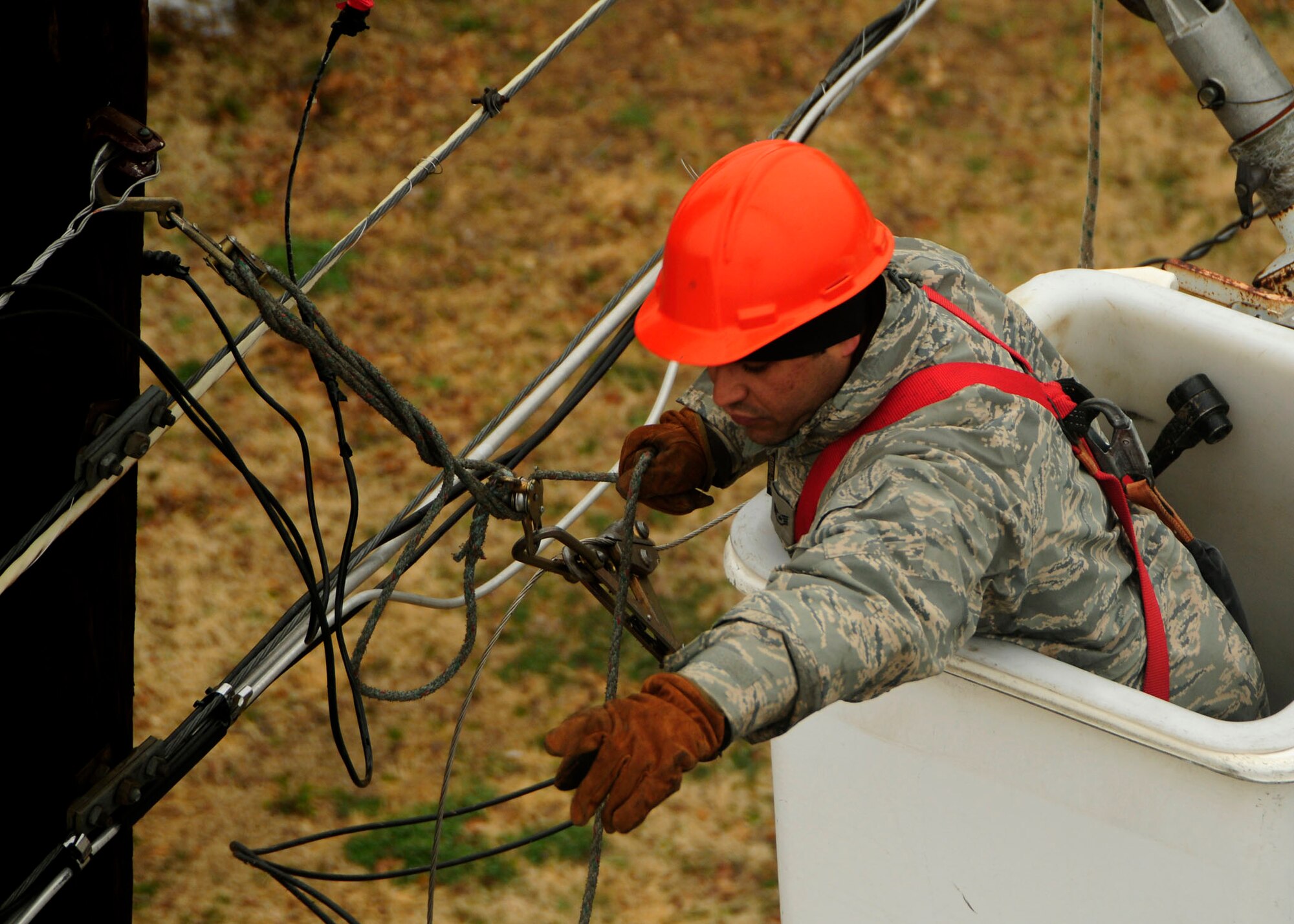 ALTUS AIR FORCE BASE, Okla. -- Staff Sgt. Armando Irizarry, from the 37th Civil Engineer Squadron of Lackland AFB, repairs a power line near the base dormitories Feb 3. Sergeant Irizarry is helping 97th Civil Engineer Squadron with its recovery effort. A severe ice storm swept through the base knocking out the power to the Altus area Jan. 28. (U.S Air Force photo/Airman 1st Class Myles T. Stepp)