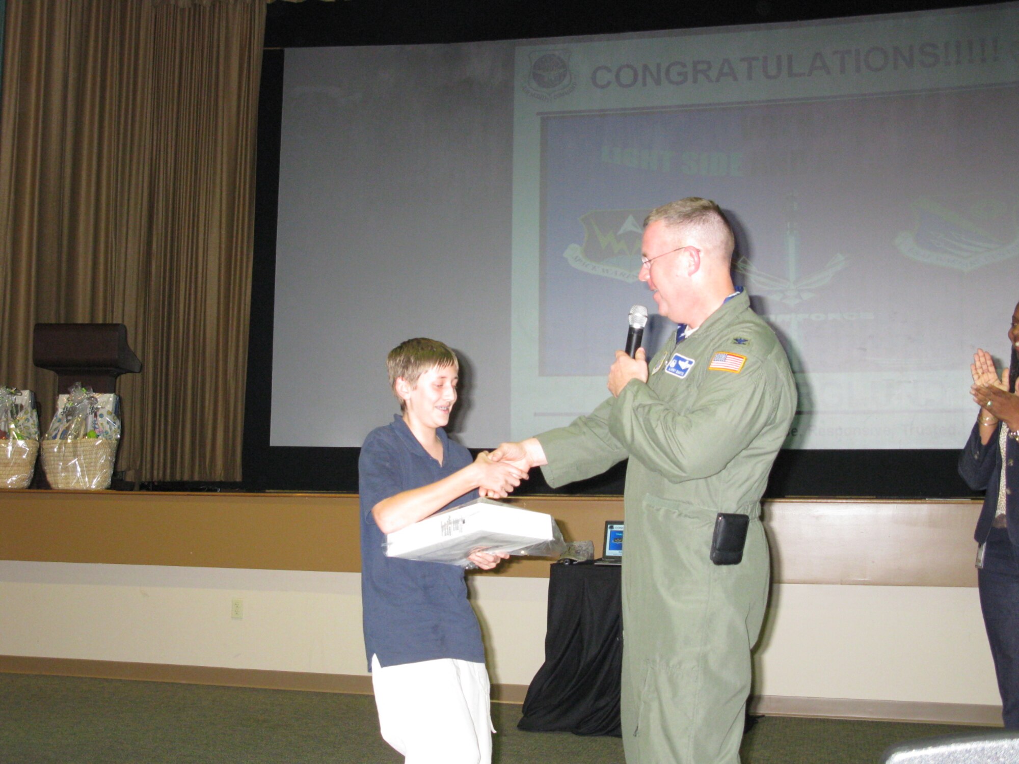 Col. Lawrence Martin, the commander of the 6th Air Mobility Wing, presented the MyAirForceLife.com T-shirt competition award to Nick Berglund at his quarterly town hall meeting in a packed base theater.