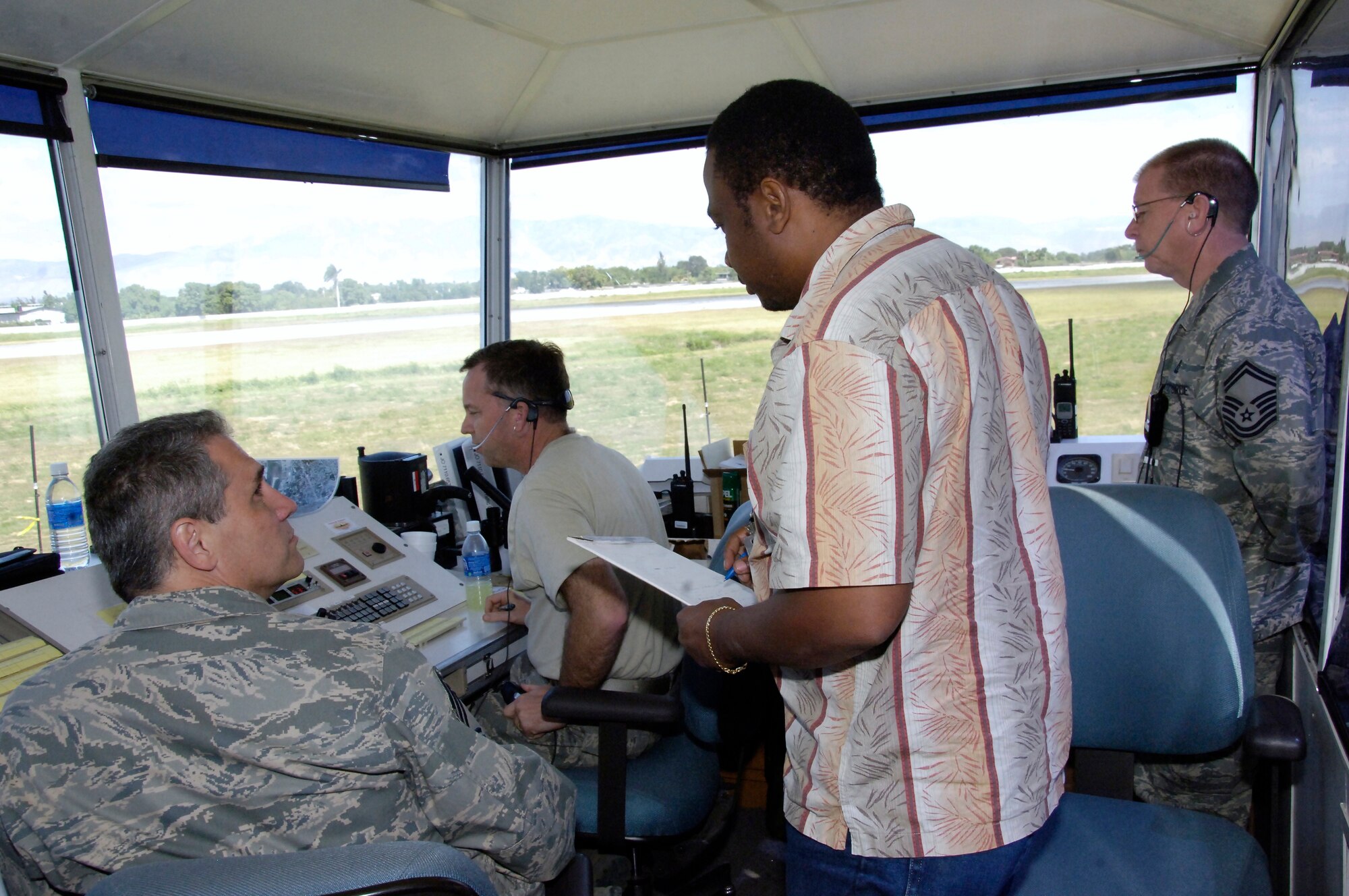 Reginald Bailey, Haitian air traffic control receives familiaization instruction from Air Force air traffic controllers in the mobile tower Feb. 1. The transition is currently taking place to hand over the tower and all flight operations responsibilities over to the Haitians.