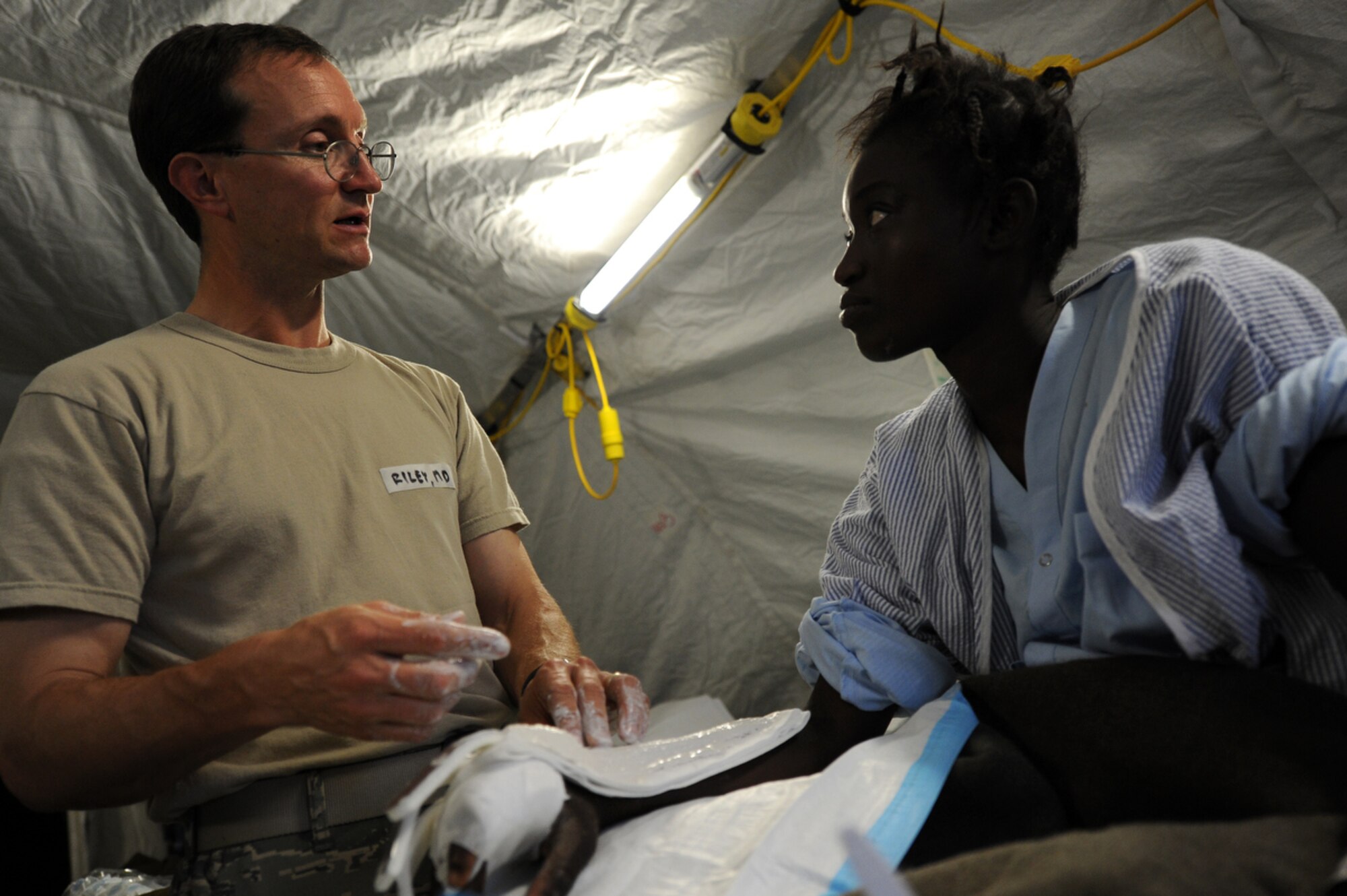 PORT AU PRINCE, Haiti -- Airmen attached to Air Force Expeditionary Medical Squadron, Four Three Six, from Travis AF Base, Sacramento Cali., and Navy Corpsman treat earthquake survivors at an expeditionary medical facility located along the harbor of Port-au-Prince, Haiti February 3, 2010. A 7.0 earthquake Tuesday, January 12, left thousands of Haitians displaced, without access to food, water and vital medical care. (U.S. Navy Photo by Mass Communication Specialist 2nd Class Todd Frantom) 
