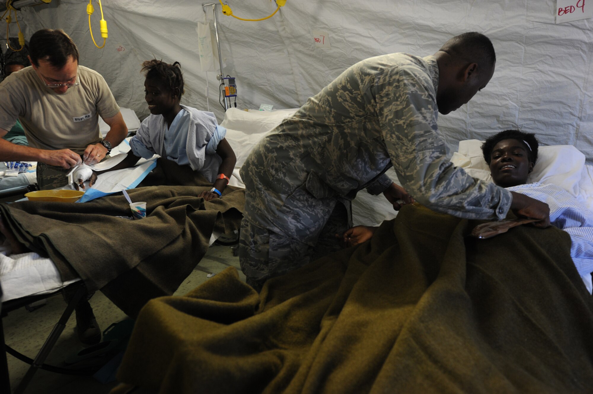 PORT-AU-PRINCE, Haiti - Airmen attached to Air Force Expeditionary Medical Squadron, Four Three Six, from Travis AF Base, Sacramento Cali., and Navy Corpsman treat earthquake survivors at an expeditionary medical facility located along the harbor of Port-au-Prince, Haiti February 3, 2010. A 7.0 earthquake Tuesday, January 12, left thousands of Haitians displaced, without access to food, water and vital medical care. (U.S. Navy Photo by Mass Communication Specialist 2nd Class Todd Frantom)