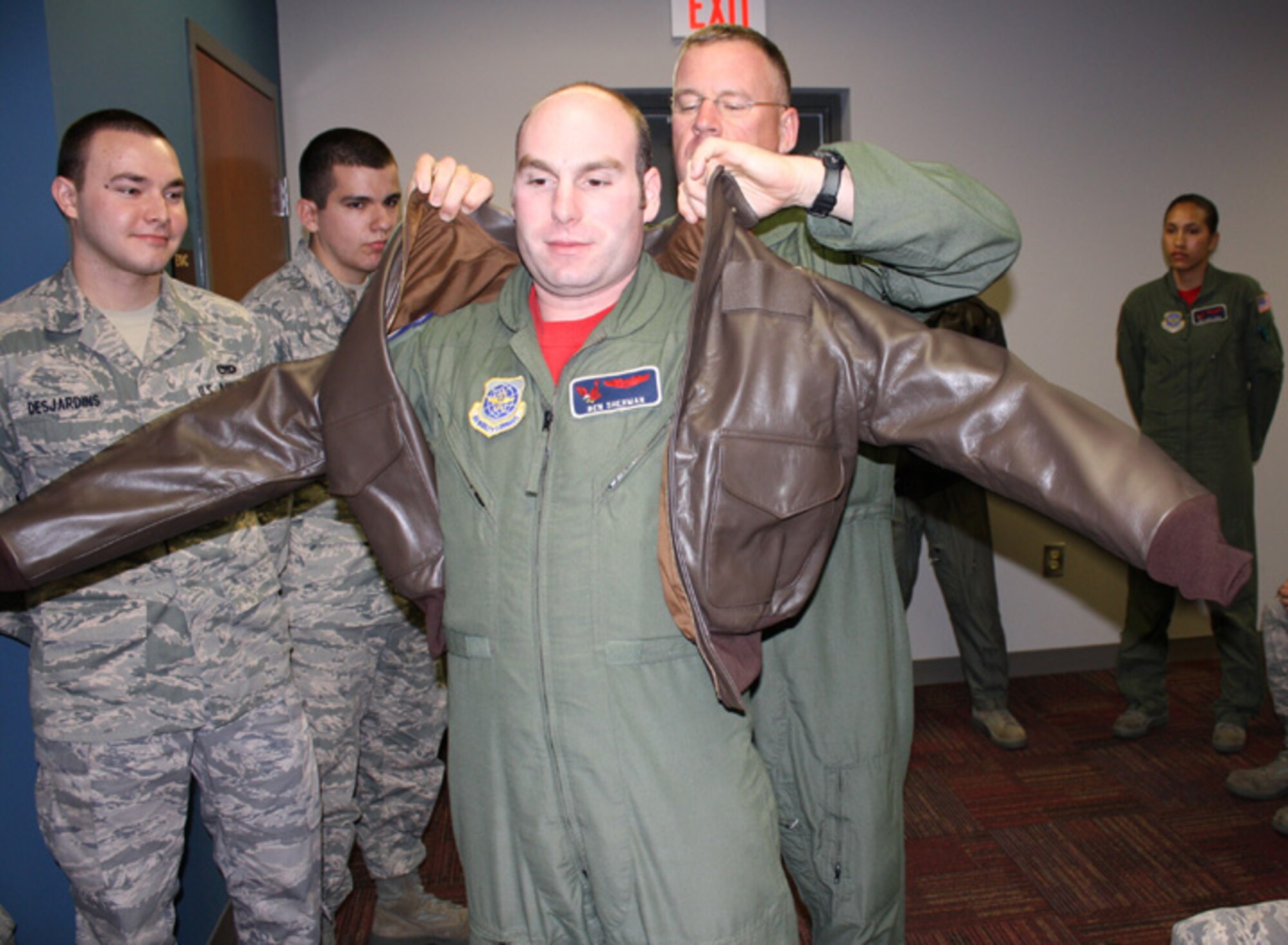 Col. Larry Martin, commander of the 6th Air Mobility Wing, assists Capt. Ben Sherman, 911th Air Refueling Squadron pilot, with his new leather jacket. (USAF photo by SSgt. Sean Gilson, 911th UPAR)
