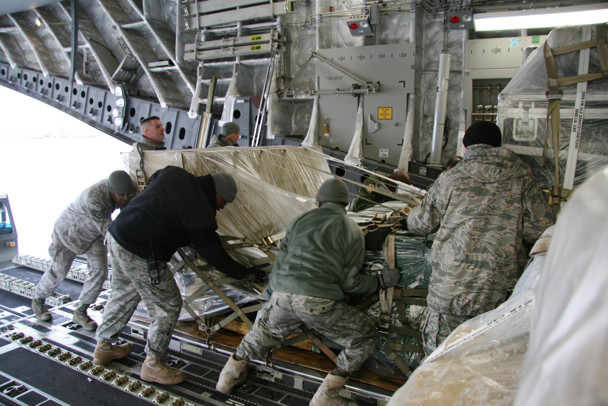 Members of the 5th Combat Communications Group push one of four pallets of equipment Sunday onto the C-17 Globemaster III that will take them to Port au Prince, Haiti. U. S. Air Force photo by 2nd Lt. Joel Cooke