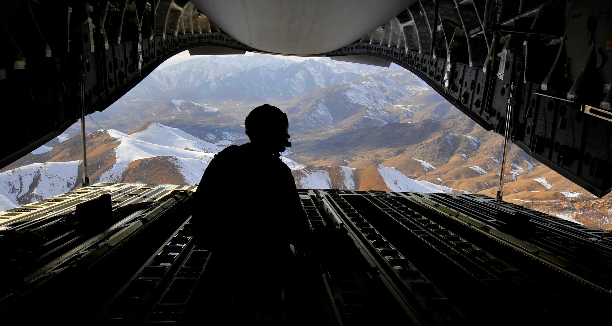 U.S. Air Force Tech. Sgt. Kevin Owen, 816th Expeditionary Airlift Squadron loadmaster, sits on the ramp of a C-17 Globemaster III while flying over the mountains of Afghanistan after an airdrop mission, Feb. 2, 2010.  Sergeant Owen and the crew airdropped 34 container delivery system bundles to a base in Afghanistan as part of a combat re-supply mission.  (U.S. Air Force photo/Staff Sgt. Angelita Lawrence/released)