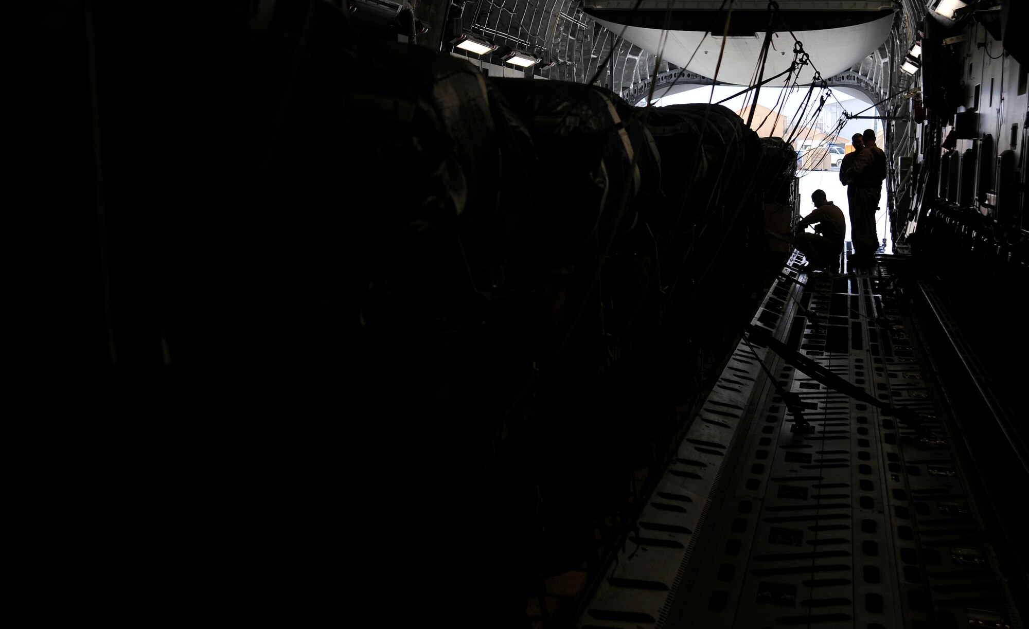 U.S. Air Force Airmen from the 816th Expeditionary Airlift Squadron strap down containerized delivery system bundles full of supplies aboard a C-17 Globemaster III, Feb. 2, 2010, at Bagram Air Field, Afghanistan.  The bundles will be delivered over a base in Afghanistan as part of a combat re-supply mission.  (U.S. Air Force photo/Staff Sgt. Angelita Lawrence/released)