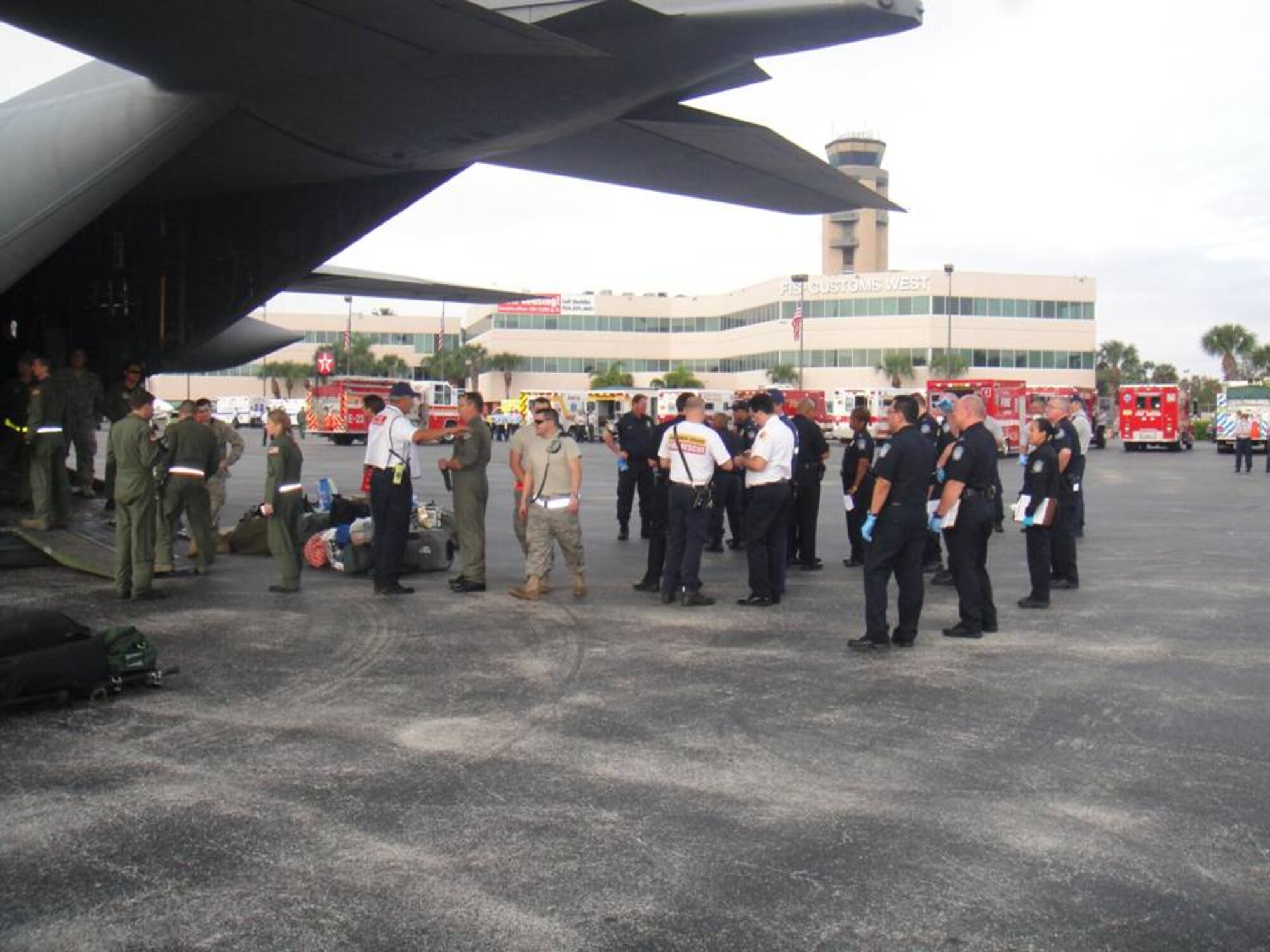 A U.S. Air Force C-130 Hercules aircrew, along with members of the Broward County Fire and Rescue and U.S. Customs and Border Patrol, prepare to unload injured Haitians at the Ft. Lauderdale International Airport General Aviation Facility on Jan. 23. (U.S. Air Force Photo by Lt. Col. Scott Tagg)