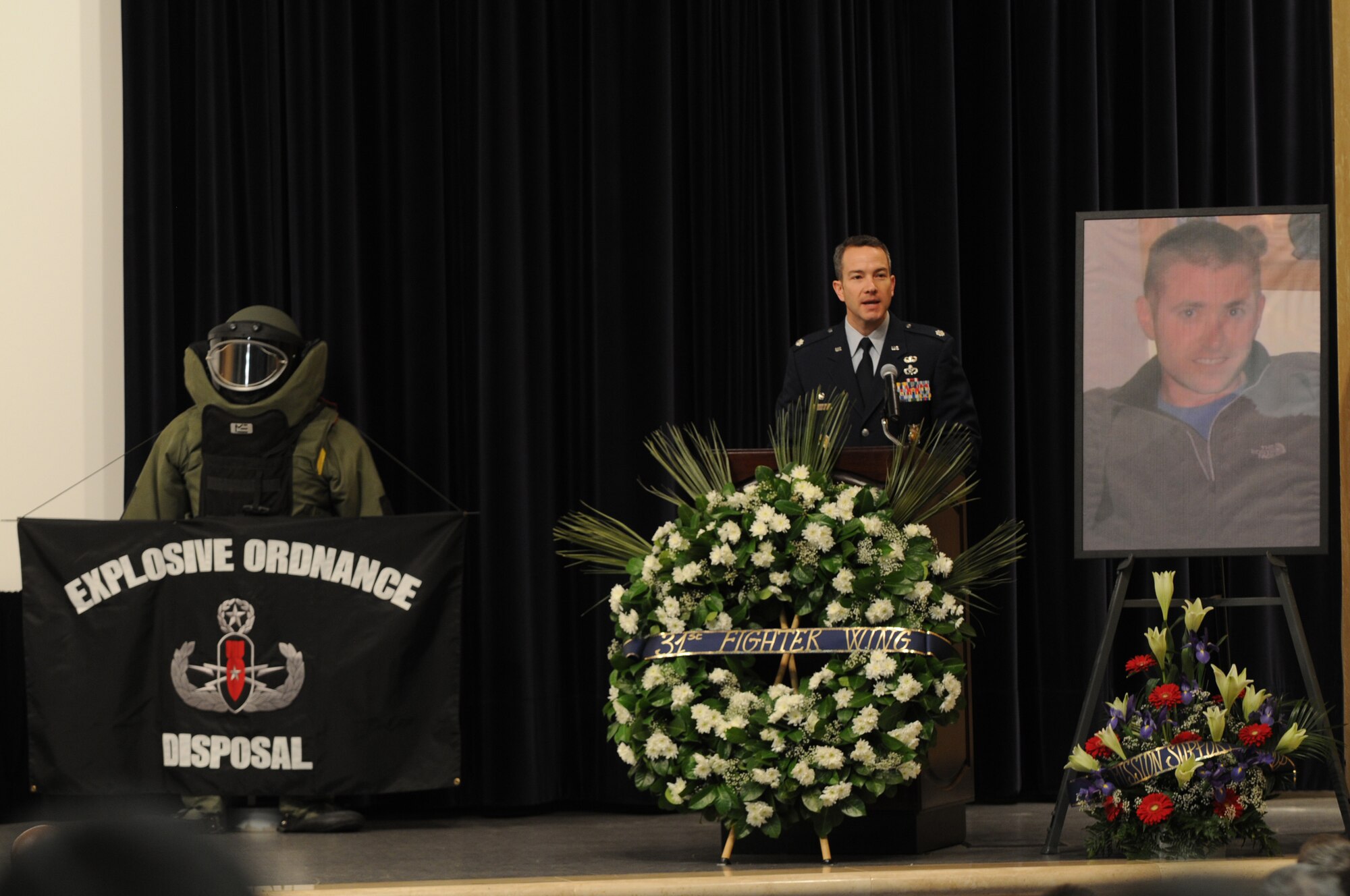 Lt. Col. Bo Bloomer, 31st Civil Engineer Squadron commander, praises Tech. Sgt. Adam K. Ginett during a memorial service held Feb. 1, 2010, at Aviano Air Base, Italy.  Sergeant Ginett, a native of Knightdale, N.C., died Jan. 19 near Kandahar Air Field, Afghanistan, of wounds suffered from an improvised explosive device. He was assigned to the 31st CES explosive ordinance disposal flight at Aviano Air Base, Italy.(U.S. Air Force photo/Staff Sgt. Mercedes Crossland)