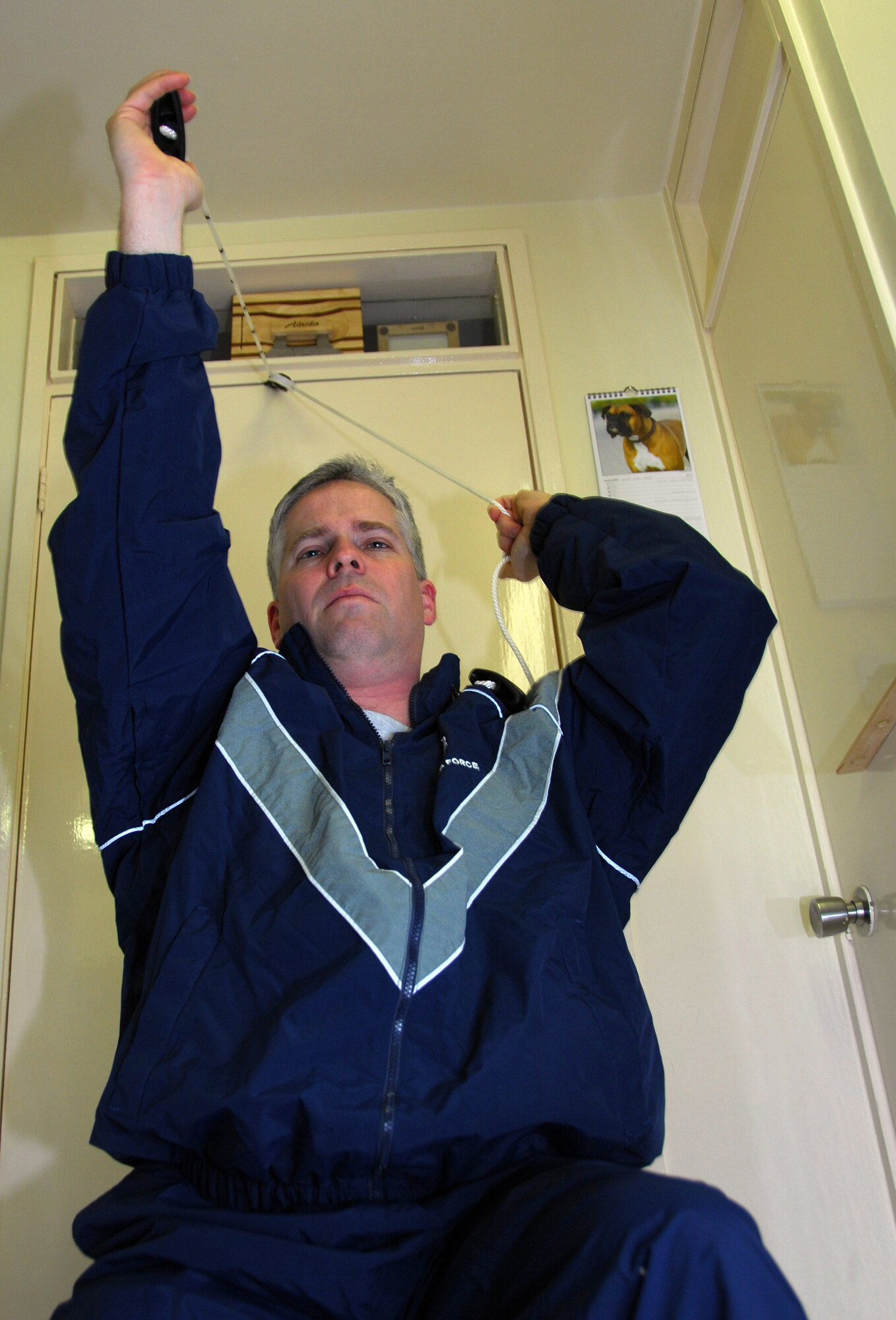 ROYAL AIR FORCE LAKENHEATH, England -- Tech. Sgt. Christopher Campbell, 48th Fighter Wing Public Affairs program manager, uses a pulley system to stretch out his shoulder as part of his physical therapy at home Jan. 24. Sergeant Campbell has several exercises to aid his recovery from shoulder surgeries; this particular motion is designed to work his flexibility. This exercise will increase his range of motion and stretch the muscles in his shoulder. (U.S. Air Force photo/Alexander Campbell)
