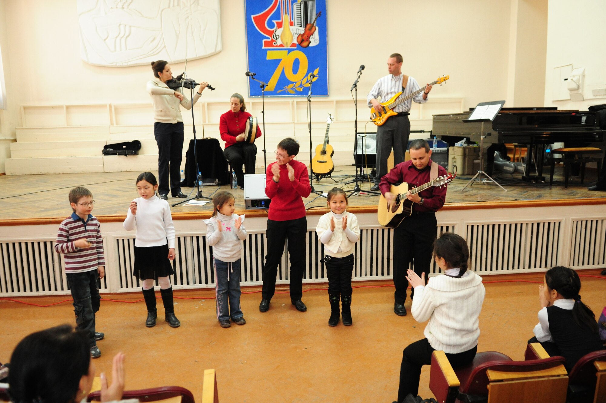 Children from the audience join "Celtic Aire," the U.S. Air Forces Central Public Affairs band, during a performance at the Shubin Music School in Bishkek, Kyrgyzstan, Feb. 1, 2010. (U.S. Air Force photo/Senior Airman Nichelle Anderson/released)
