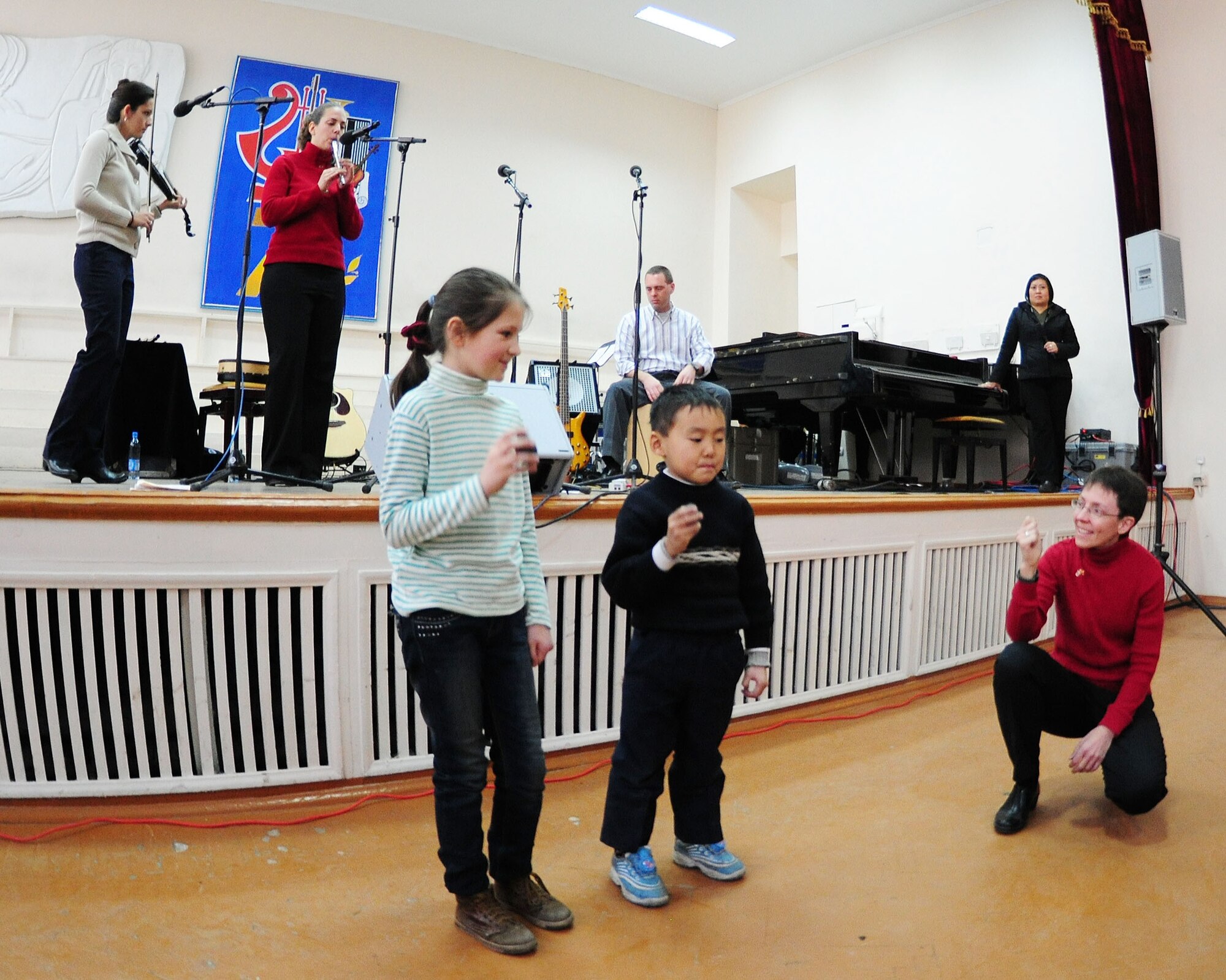 Children from the audience join "Celtic Aire," the U.S. Air Forces Central Public Affairs band, during a performance at the Shubin Music School in Bishkek, Kyrgyzstan, Feb. 1, 2010. (U.S. Air Force photo/Senior Airman Nichelle Anderson/released)