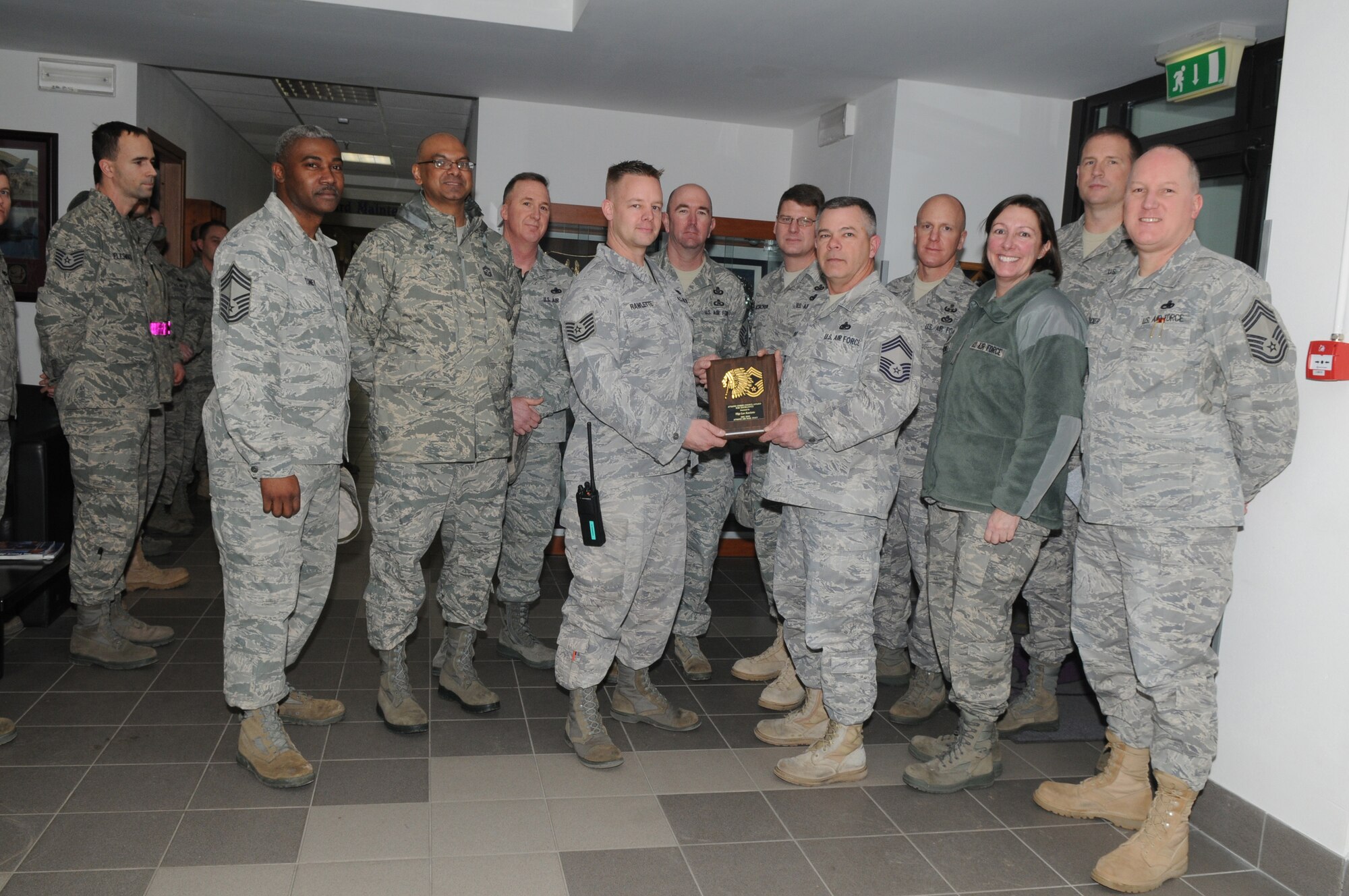 Tech. Sgt. Lee Rawlette, 31st Aircraft Maintenance Squadron, receives the Aviano Chief's Choice Award for December 2009 from Chief Master Sgt. Richard Lander, 31st Aircraft Maintenance Squadron chief enlisted manager, (center right) along with fellow Aviano chiefs. (U.S. Air Force photo/Staff Sgt. Mercedes Crossland)