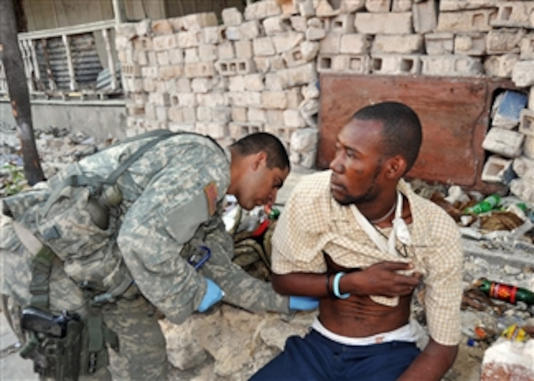A U.S. Army medic assigned to the 82nd Airborne Division gives medical care to an injured man in Port-au-Prince, Haiti, on Jan. 31, 2010.  The United States and other international military and civilian aid agencies are conducting humanitarian and disaster relief operations as part of Operation Unified Response in the aftermath of the earthquake that hit the area on Jan. 12, 2010.  