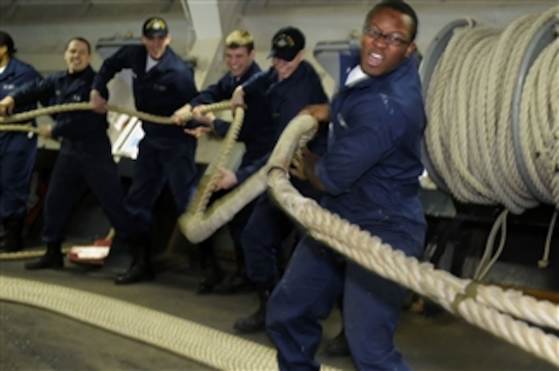 U.S. Navy Seaman Darrell Moore and fellow line-handlers heave a mooring line in the forecastle aboard the U.S. 7th Fleet command ship USS Blue Ridge (LCC 19) in Yokosuka, Japan, on Feb. 1, 2010.  
